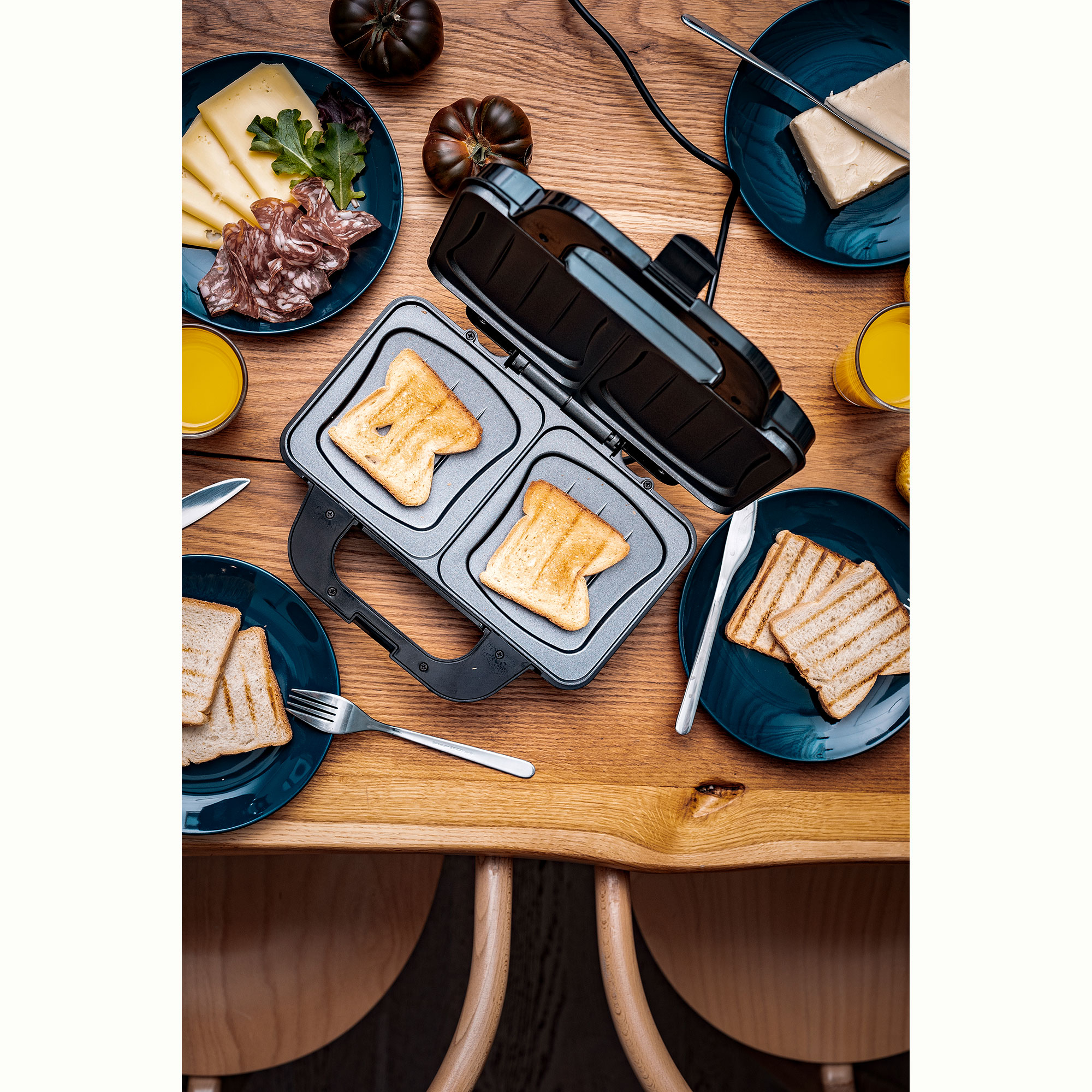 Toster z dwoma tostami, podane z serem, szynką i sokiem.