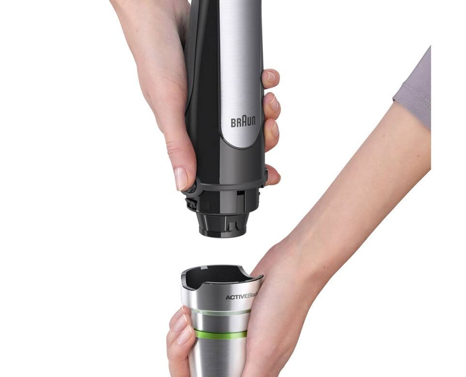 Manos ensamblando una batidora de mano Braun negra y plateada con un accesorio ActiveBlade verde y plateado.
