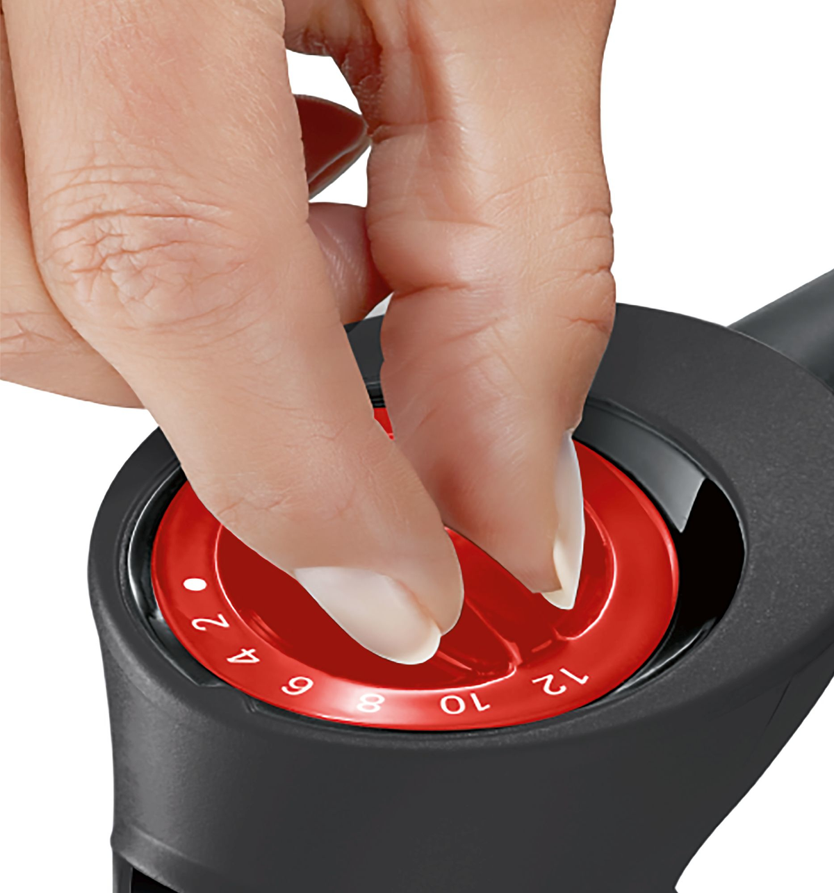 Ręka regulująca czerwone pokrętło z numerami, prawdopodobnie do odkurzacza.