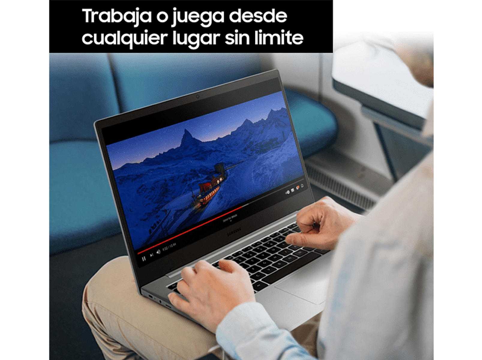 Persona usando portátil, viendo video. Pantalla muestra paisaje. Portátil en su regazo.