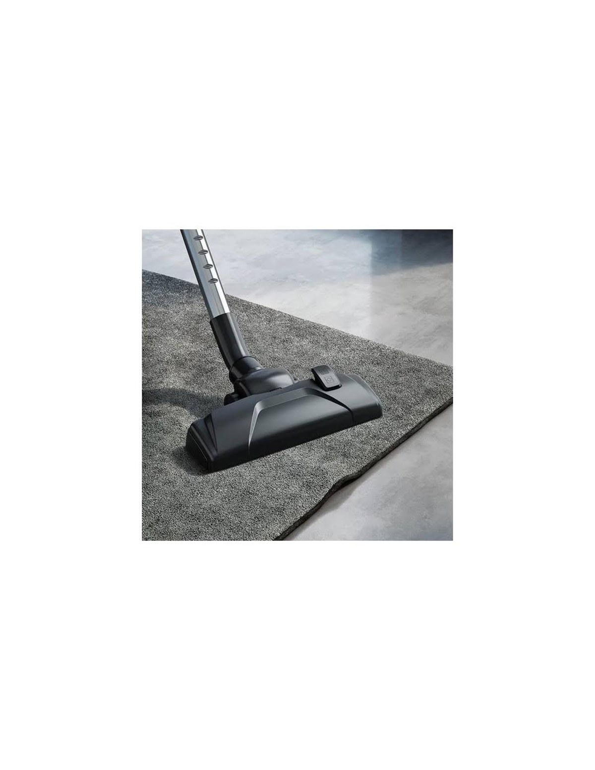 Głowica odkurzacza na szarym dywanie i podłodze.