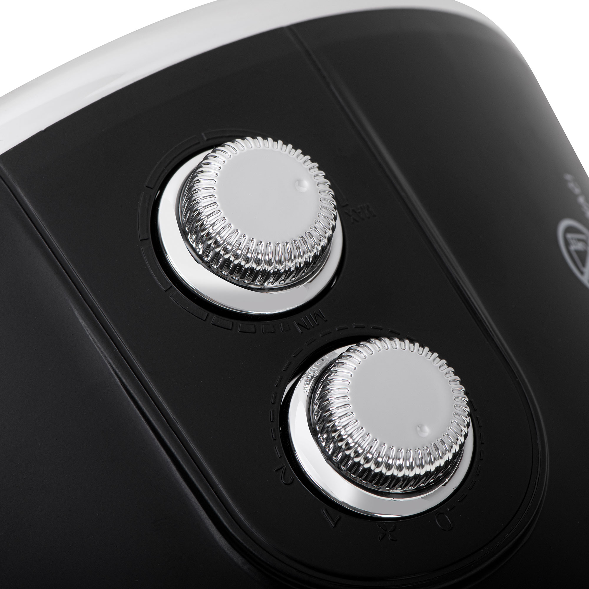 Zbliżenie czarnego urządzenia z dwoma srebrnymi pokrętłami na białej powierzchni.