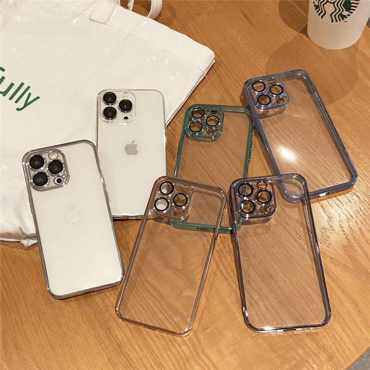 Sortiment von Handyhüllen und iPhones auf einem Holztisch.