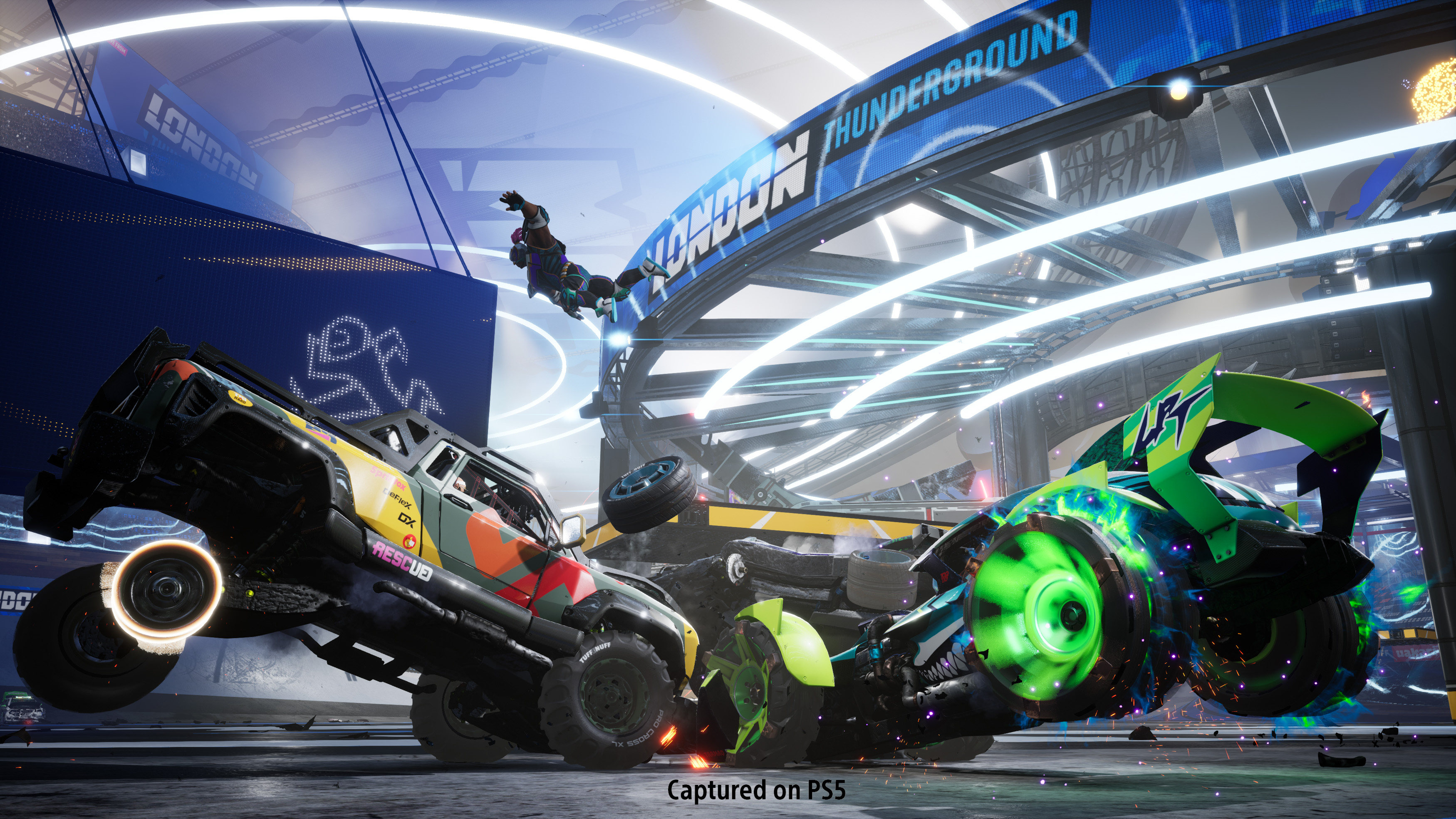 Zwei Autos kollidieren in einer futuristischen Arena in der Luft. Eine Figur fliegt. Die Szene ist lebendig.