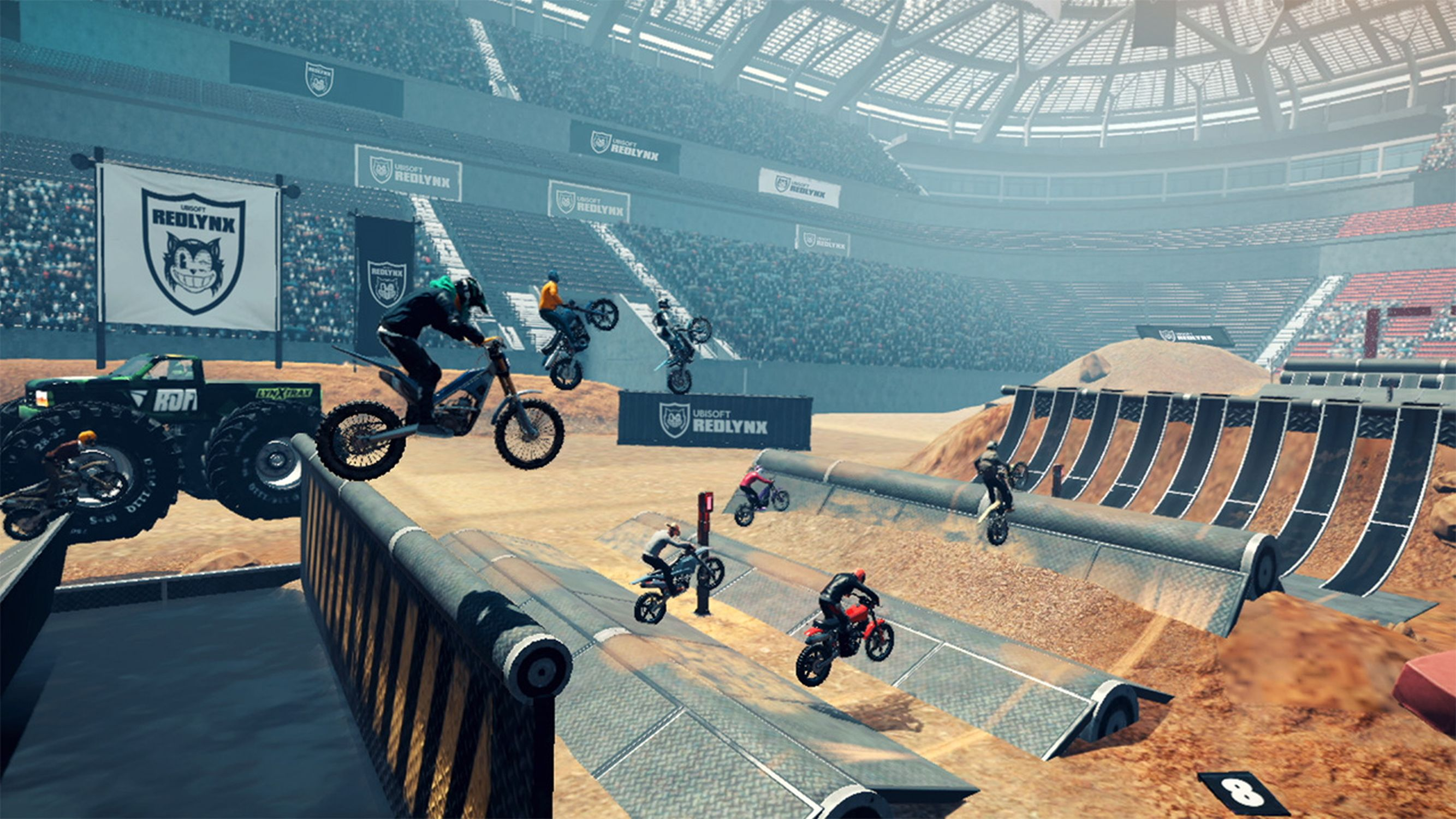 Eine Videospielszenen mit Motorrädern, Rampen und Publikum. Es ist in einer Arena.