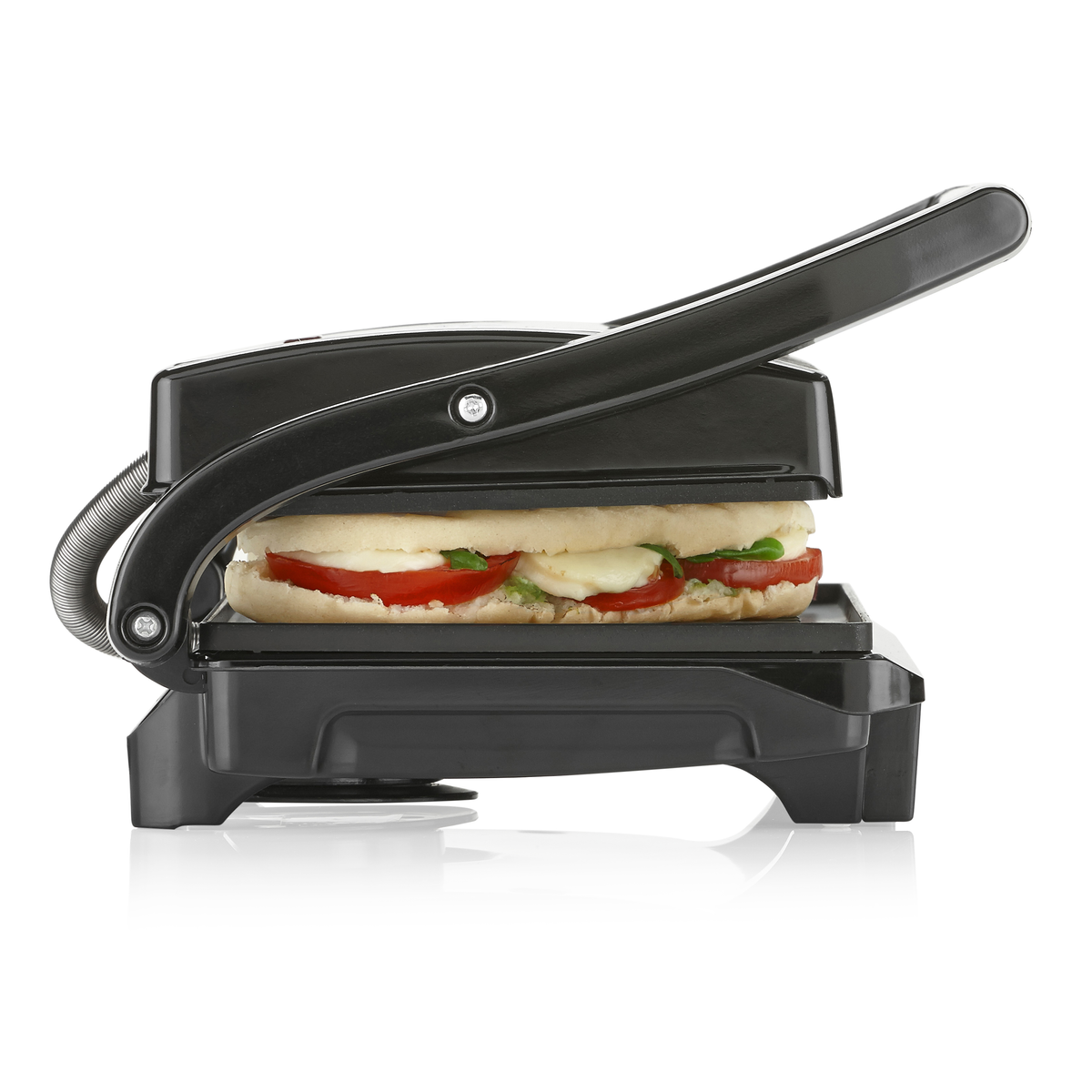 Prensa panini negra abierta, con sándwich de tomate, mozzarella y albahaca.