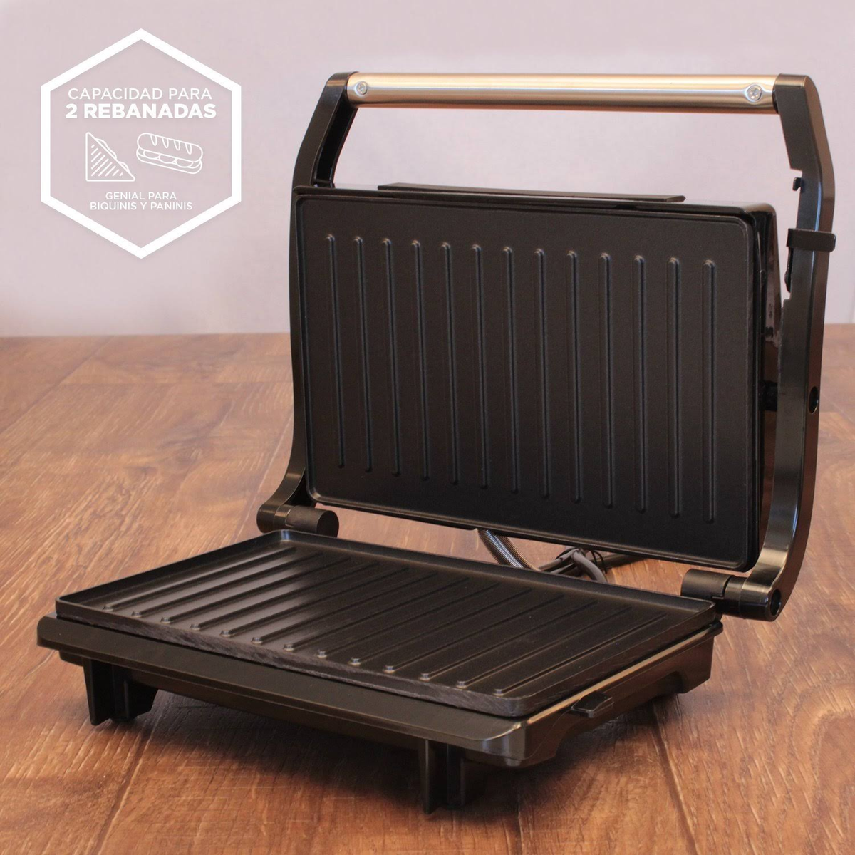 Sandwich maker nero aperto su legno. Ha una maniglia e testo di capacità.