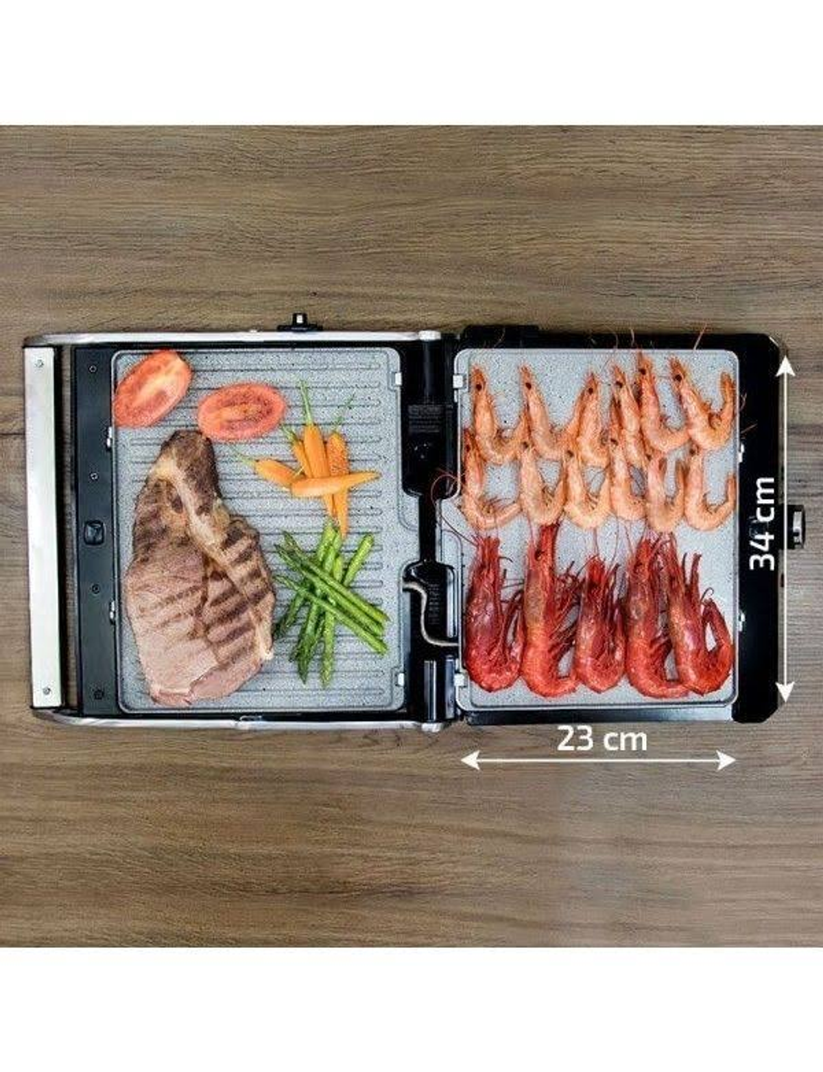 Otwarta prasa do panini z jedzeniem: stek, krewetki, pomidory, marchew i szparagi.