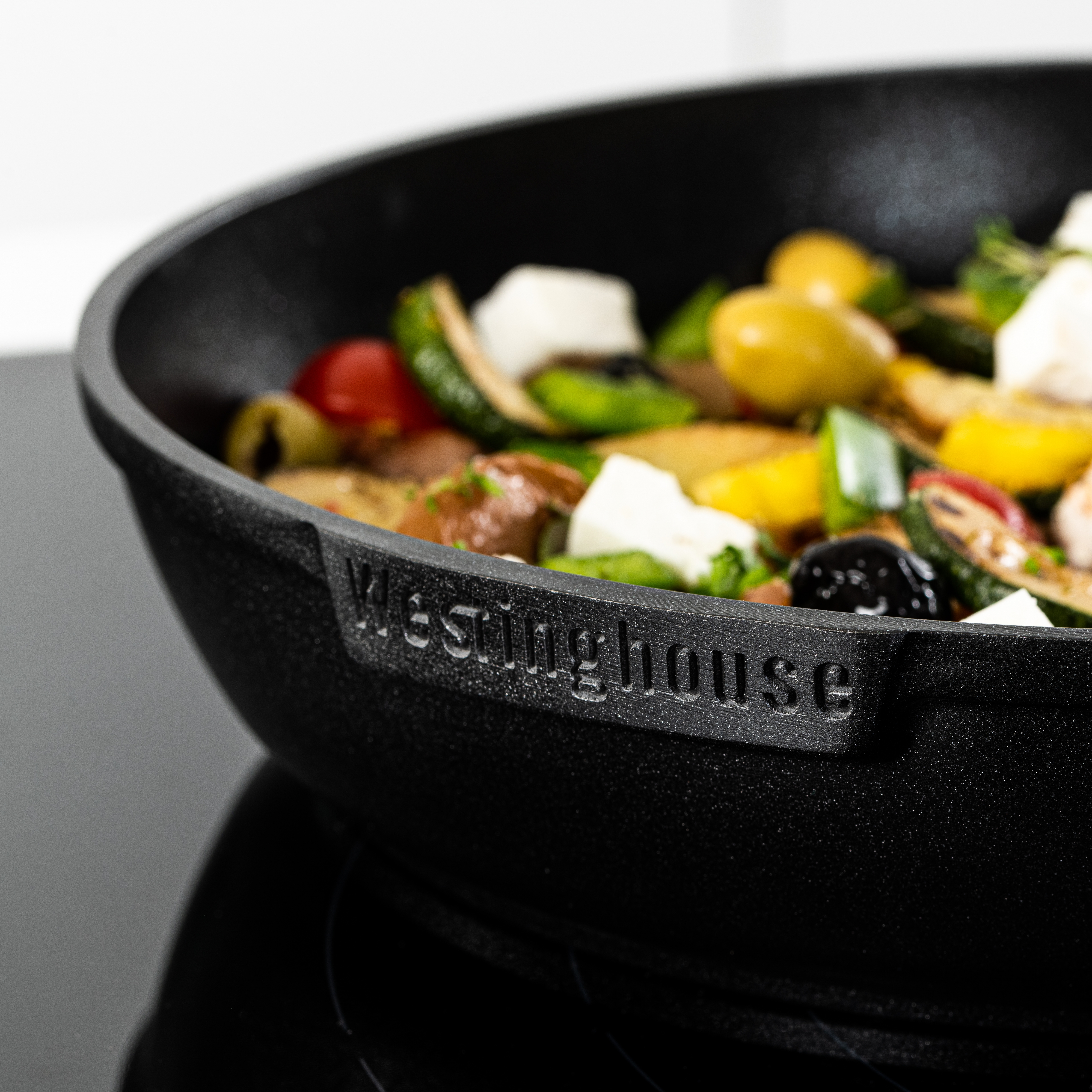Nahaufnahme einer Bratpfanne mit gekochtem Gemüse. Die Pfanne ist schwarz und hat das Wort "Westinghouse" eingraviert.