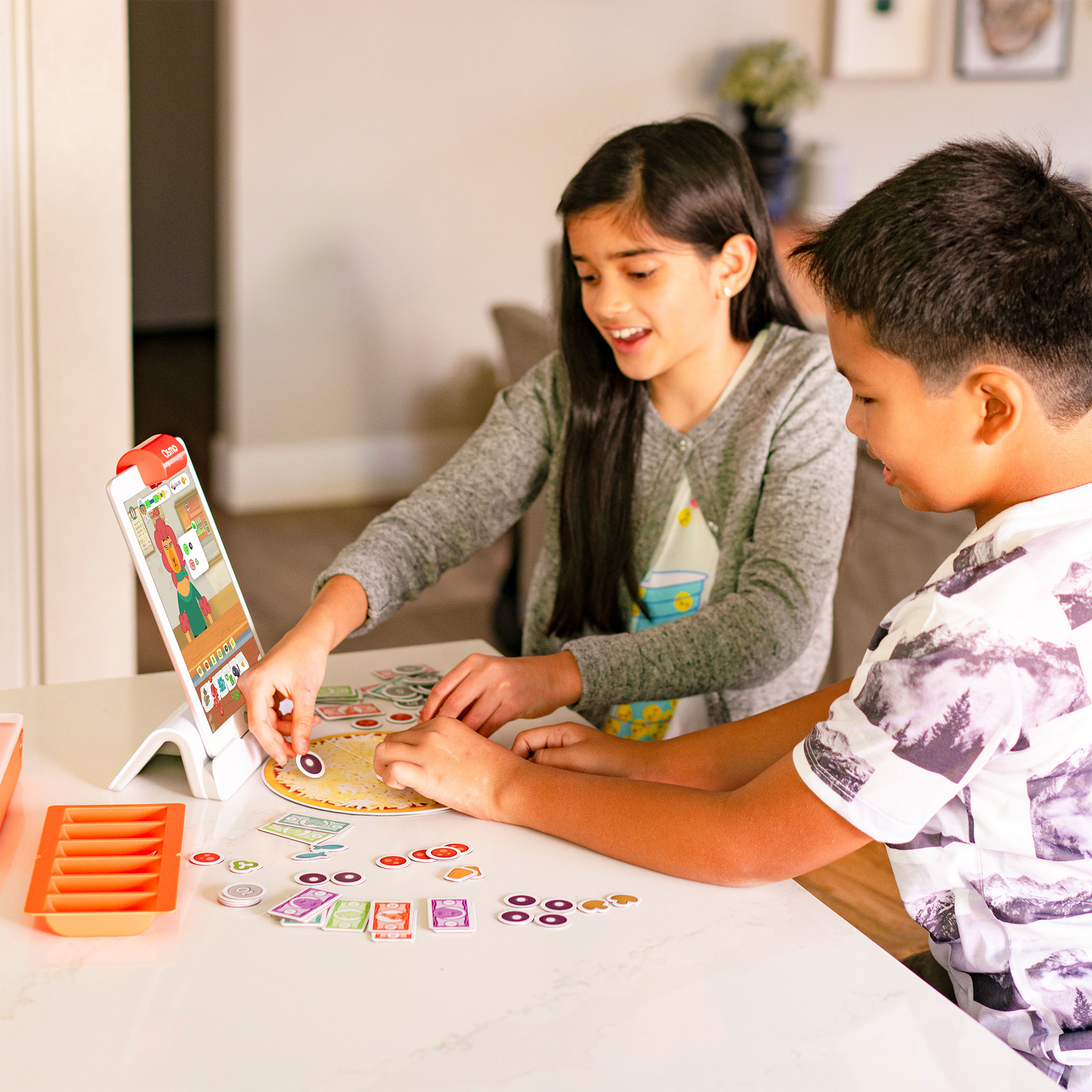Zwei Kinder spielen ein Brettspiel. Ein Kind zeigt auf das Spielbrett. Das Spiel ist auf einem Tisch.