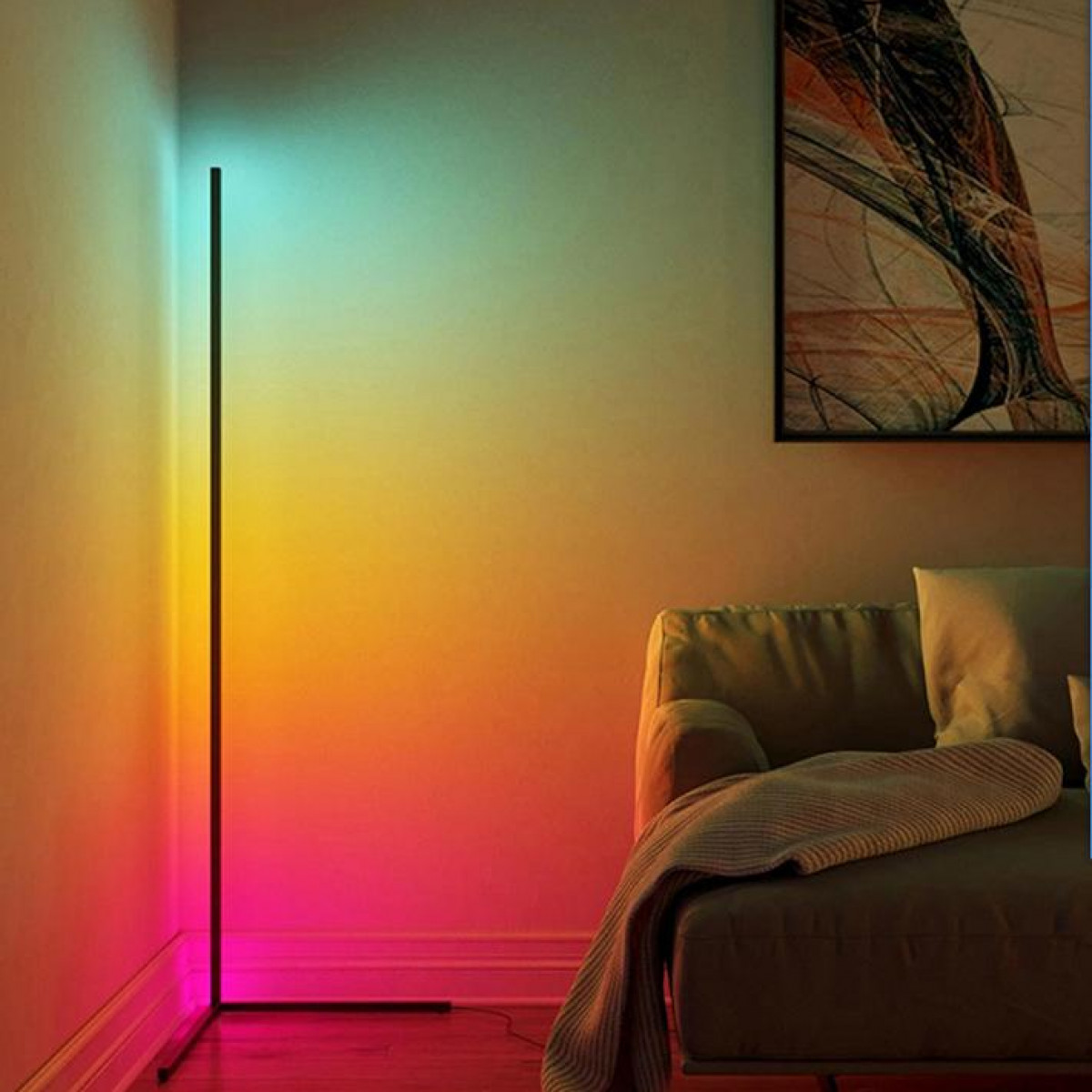 Stehlampe mit Farbverlauf, von Rot nach Gelb. Sofa und Kunstwerk im Hintergrund.