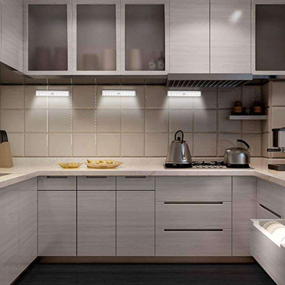 Een keuken met lichten boven de kasten en aanrechtbladen. De lichten zijn aan.