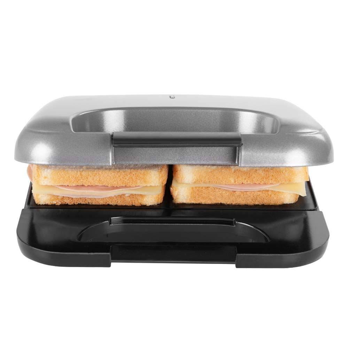 Sandwichera con dos sándwiches dentro. Pan, jamón y queso visibles. Color gris.
