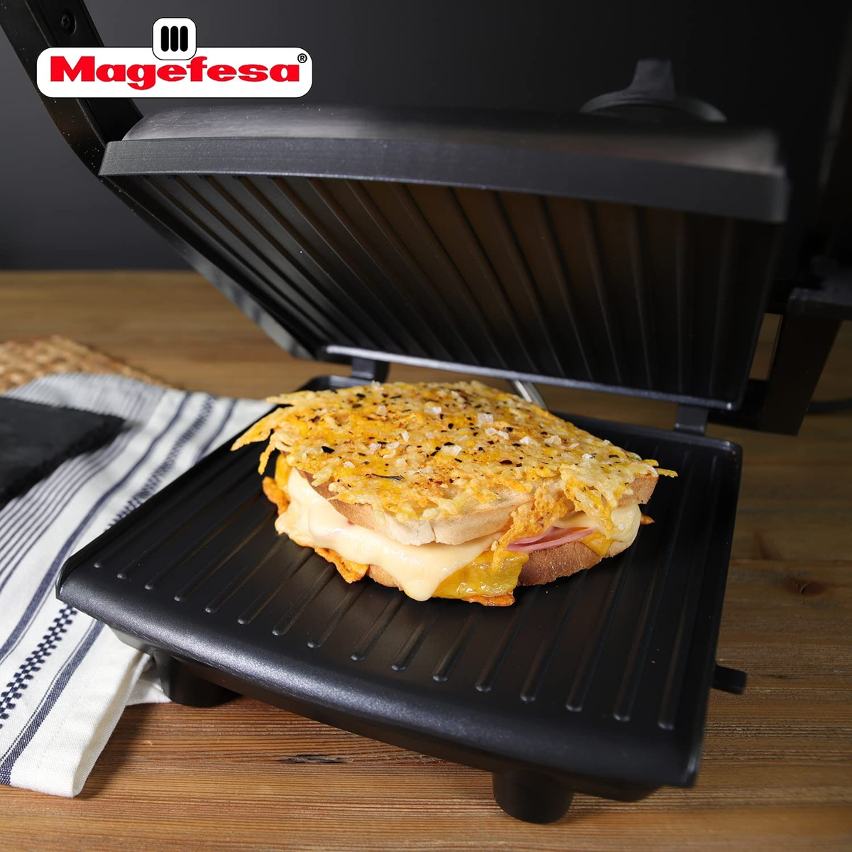 Un sándwich en una parrilla, con queso derretido, dentro de un aparato de cocina cerrado.
