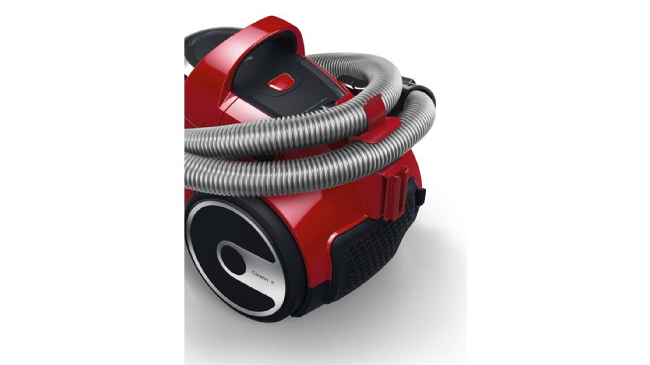 Czerwony odkurzacz ze zwiniętym wężem. Czarne akcenty. Białe tło.