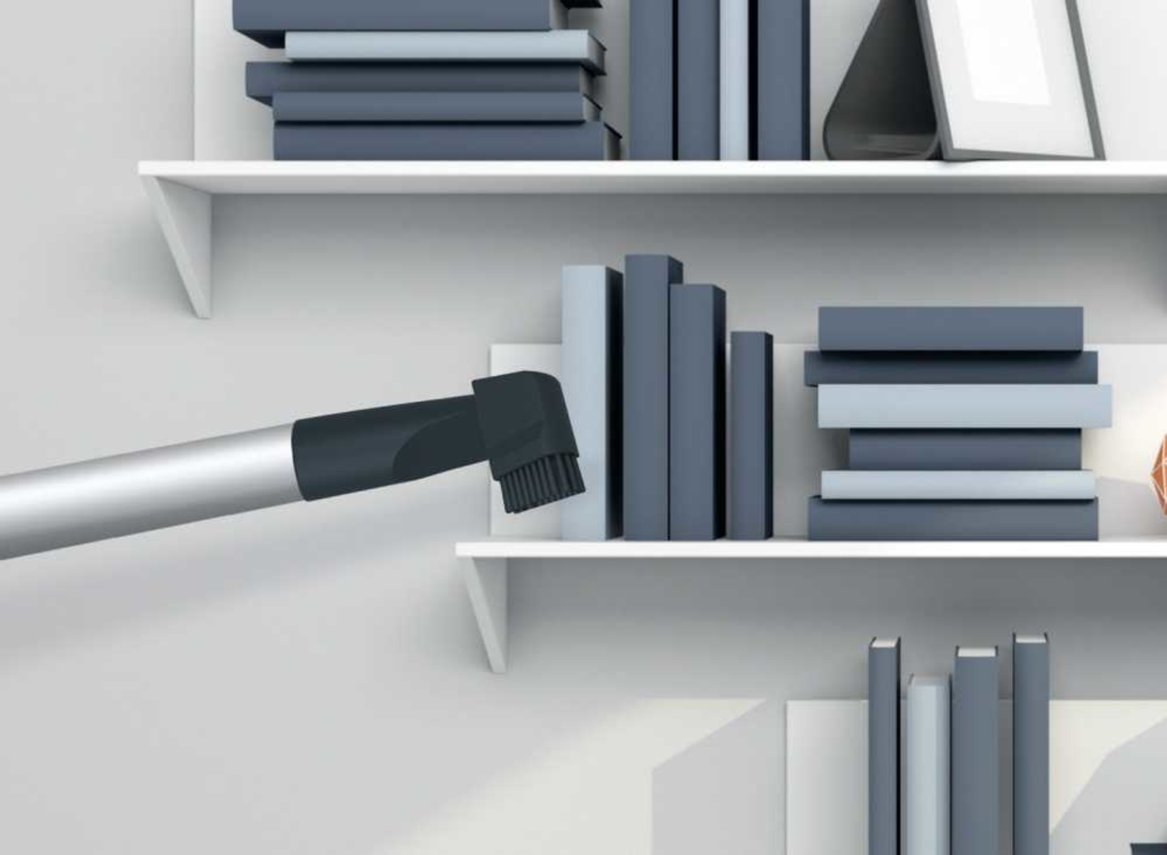 Odkurzacz czyszczący półkę z książkami.