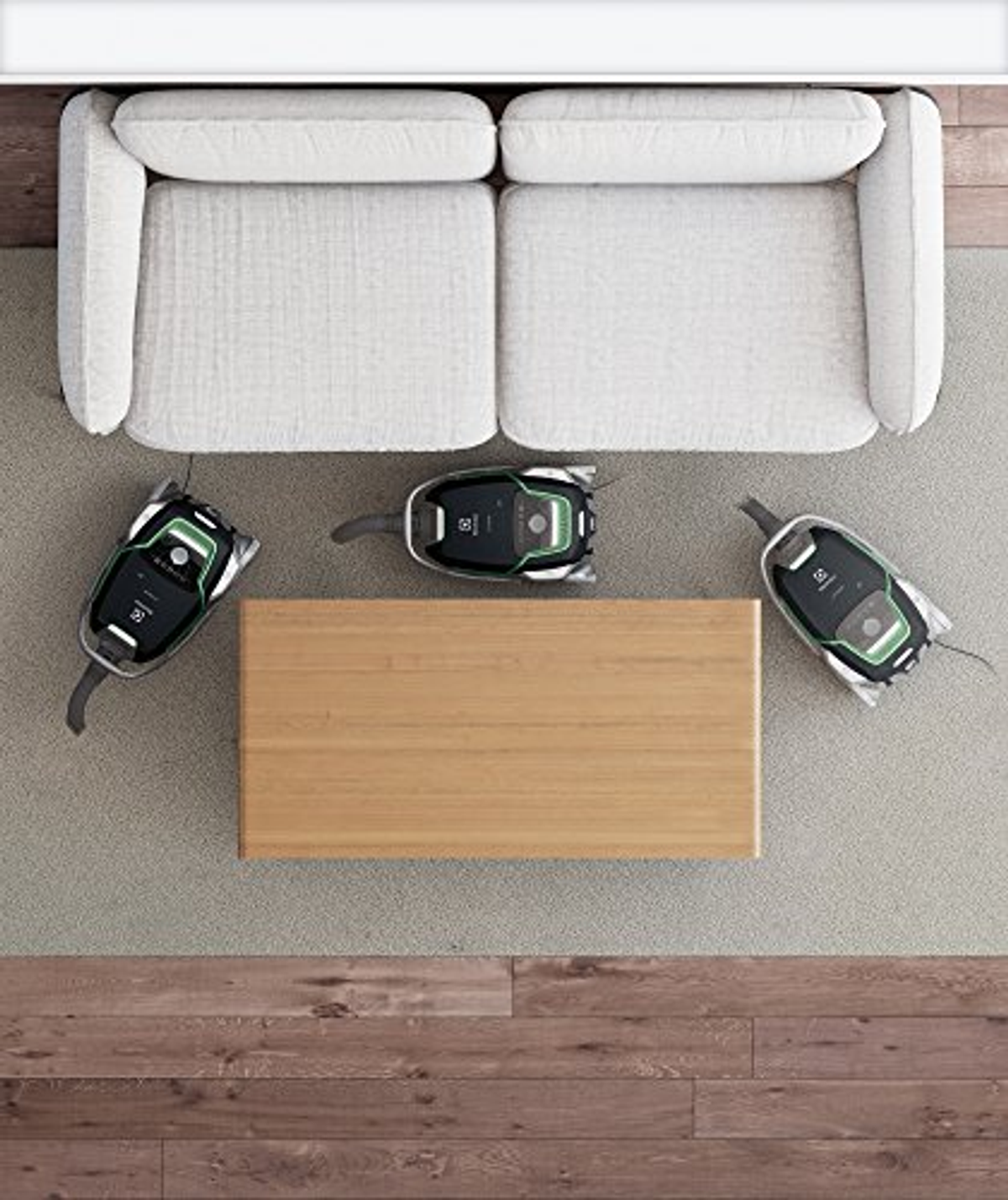 Widok z góry na trzy odkurzacze i stolik kawowy. Trzy odkurzacze na szarej wykładzinie, drewniany stół.