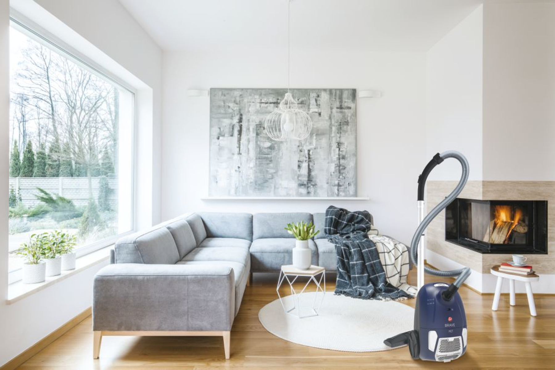 Scena z salonu z niebieskim odkurzaczem. Kominek i sofa w tle.