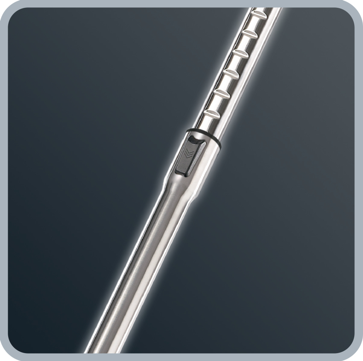 Zbliżenie srebrnej rury odkurzacza z przyciskiem i żebrami.