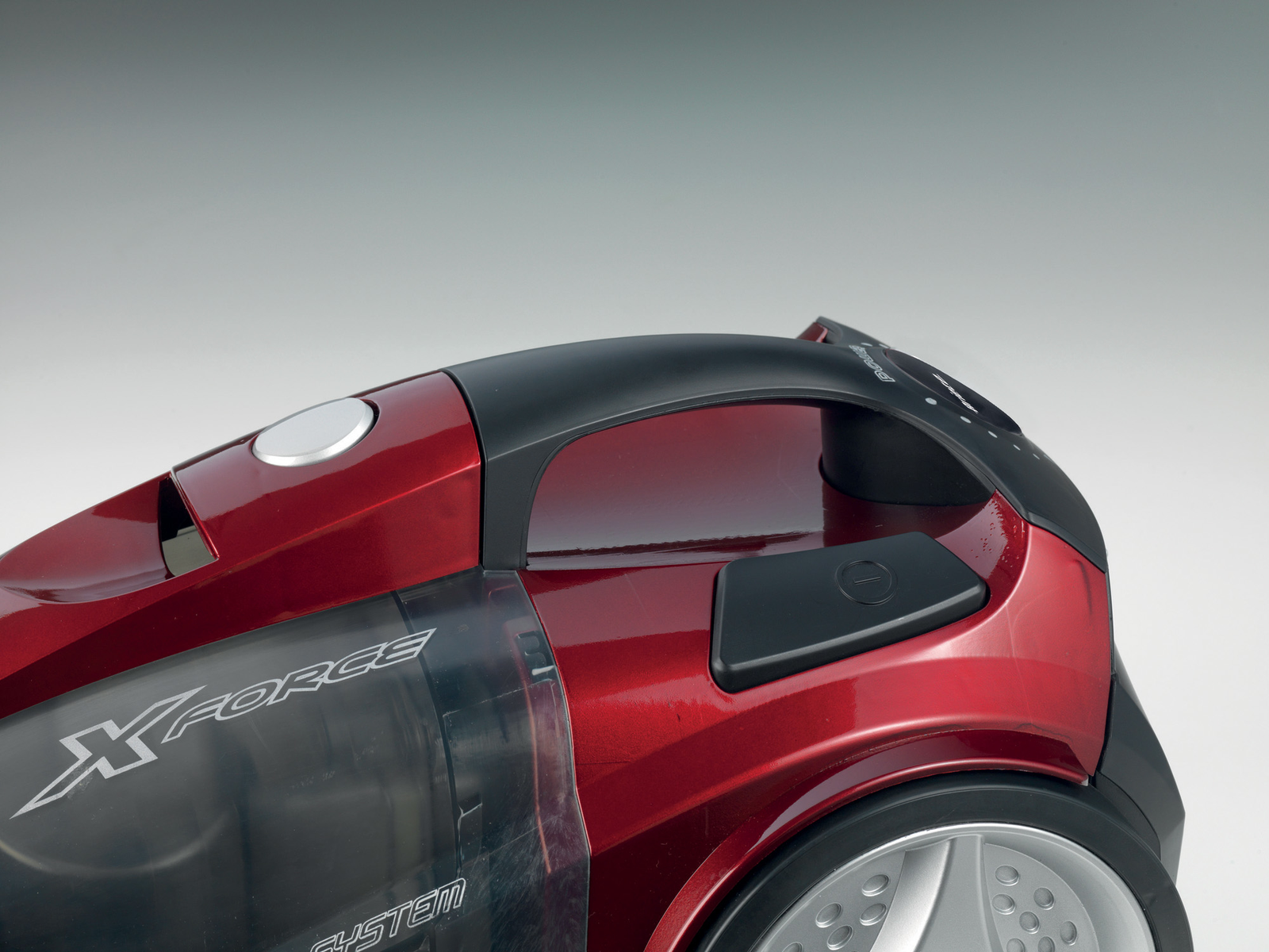 Czerwony odkurzacz z czarnymi detalami. Zdjęcie jest zbliżeniem na białym tle.