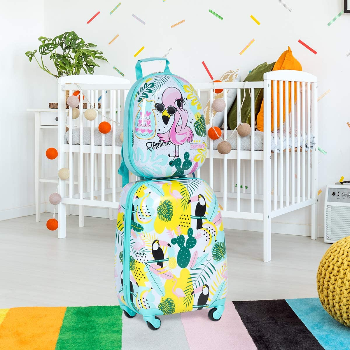 Ein Koffer und ein Rucksack, beide mit Flamingo- und Tukanmustern, stehen in einem Raum mit einem Kinderbett.