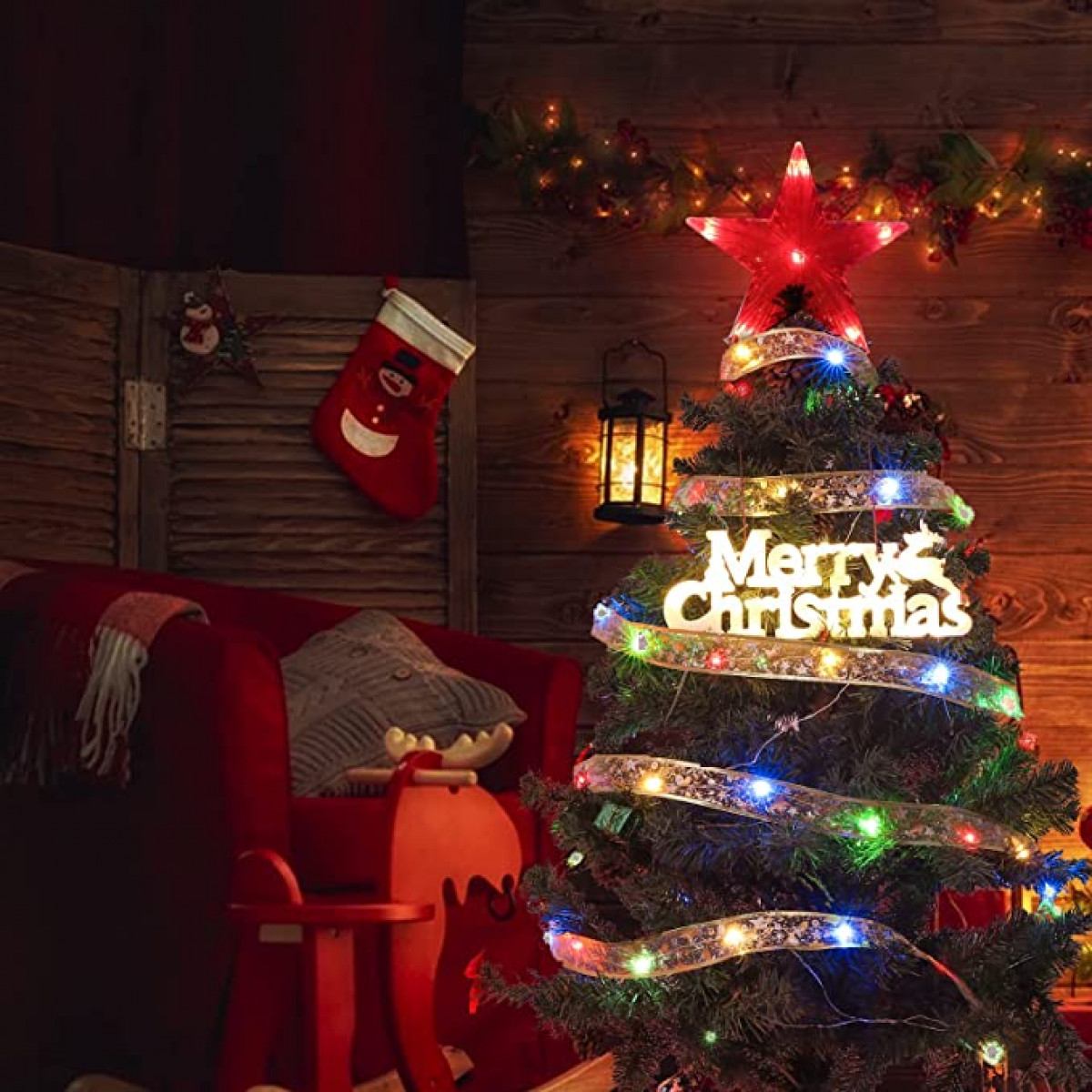 Ein Weihnachtsbaum ist mit Lichtern, einem Stern und einem Banner mit der Aufschrift 'Merry Christmas' geschmückt.