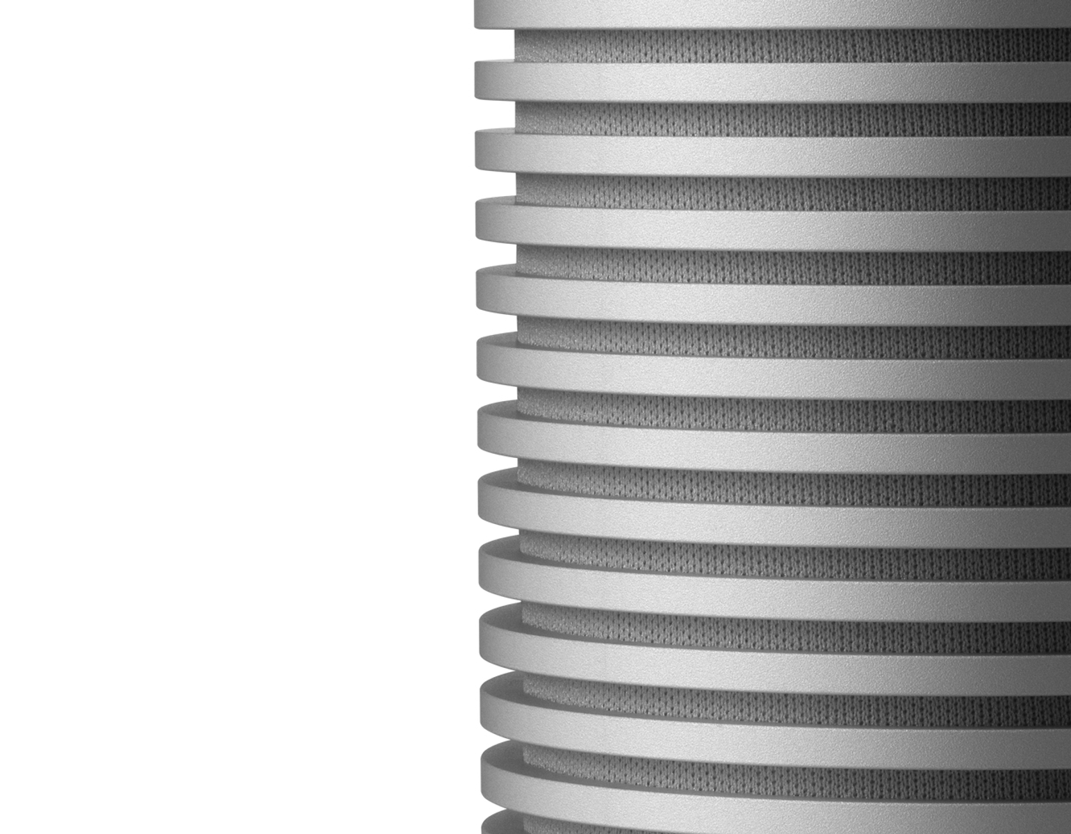 Zbliżenie cylindrycznego metalowego obiektu z poziomymi żebrami na białym tle.