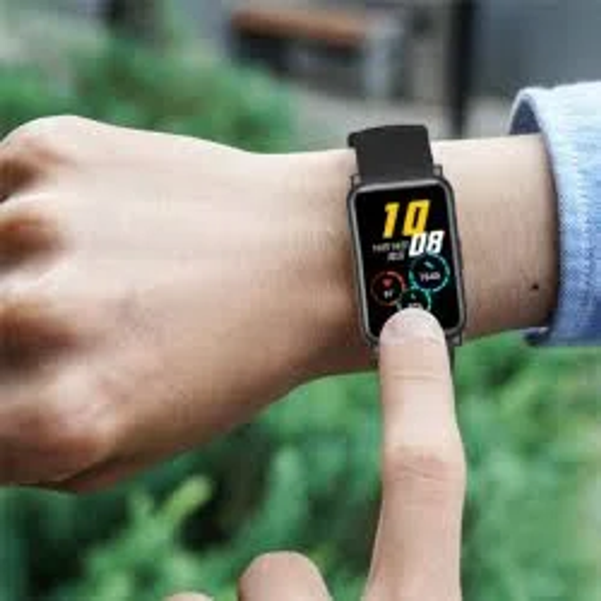 Mano de una persona con un reloj inteligente negro. Muestra la hora y métricas de salud.