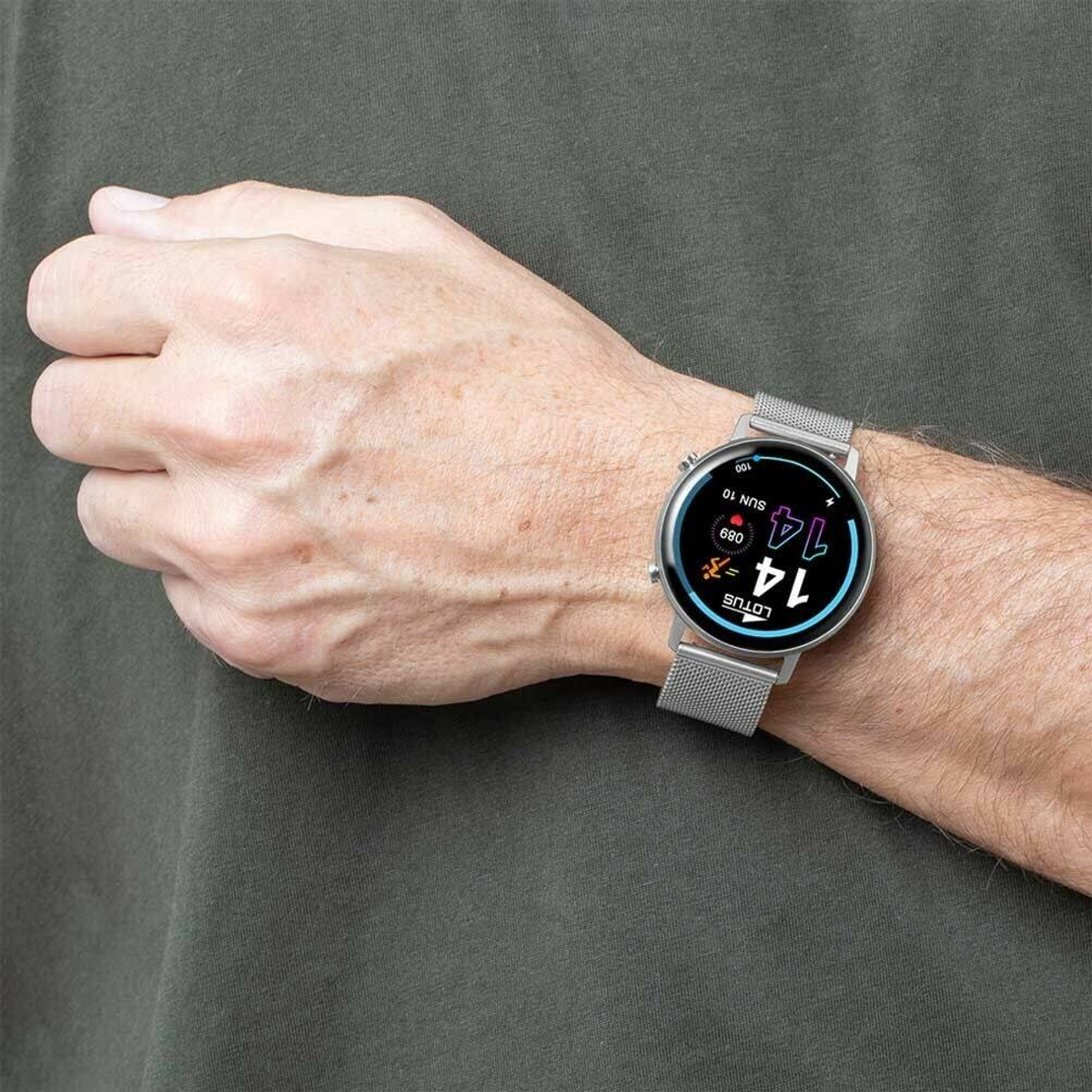 Nadgarstek osoby noszącej smartwatch marki Lotus, wyświetlający datę i godzinę. Pasek jest srebrny.