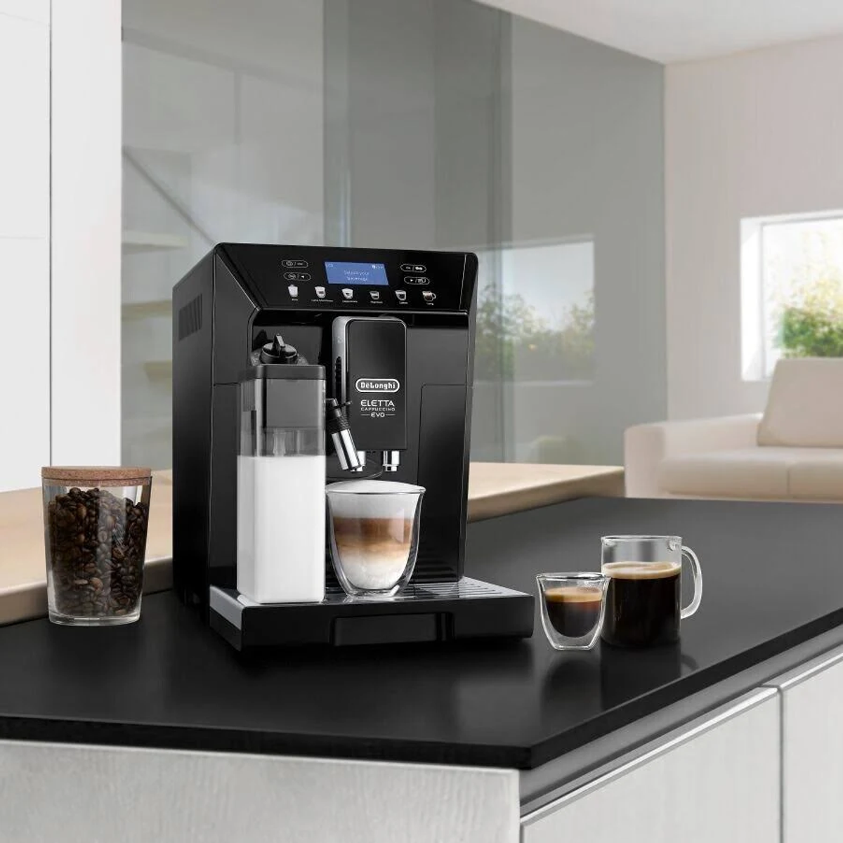 Machine à café noire avec café et lait dans des verres, plus grains de café dans un bocal.