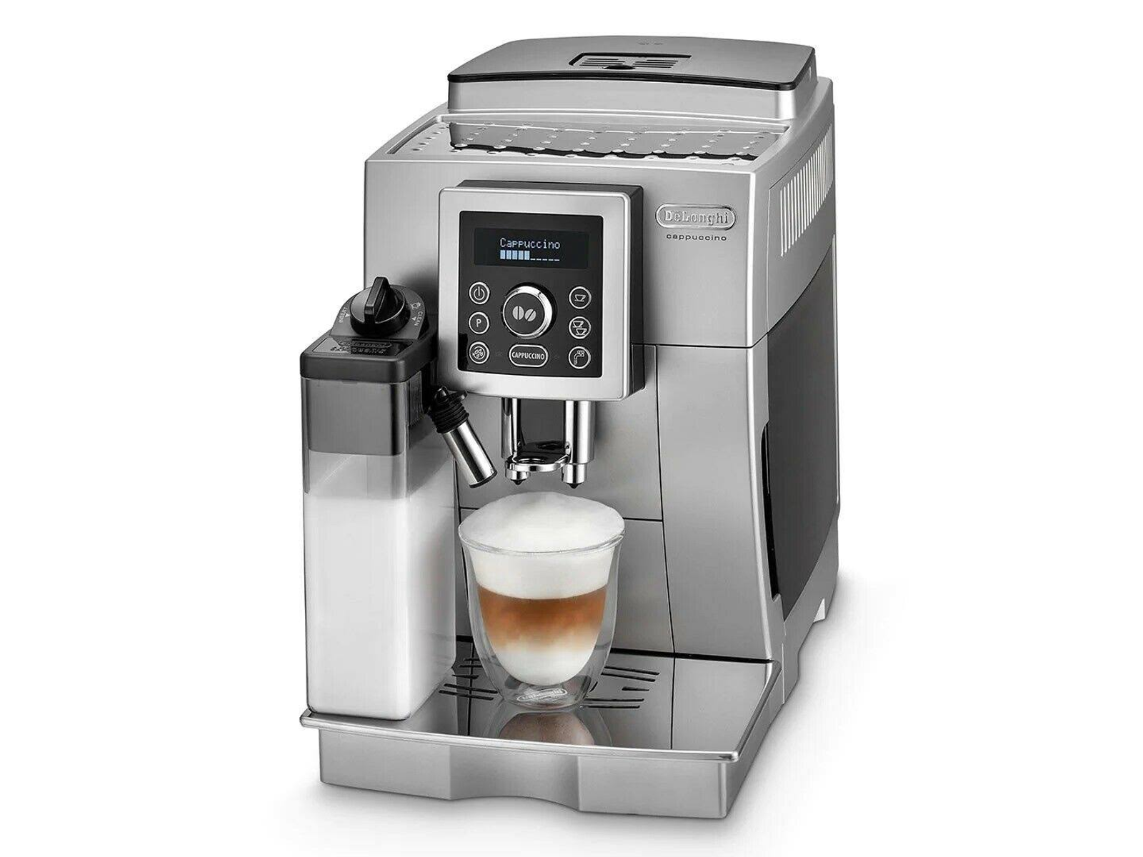 Cafetera espresso plateada con una taza de capuchino. Un recipiente de leche está a la izquierda. La pantalla muestra ajustes.