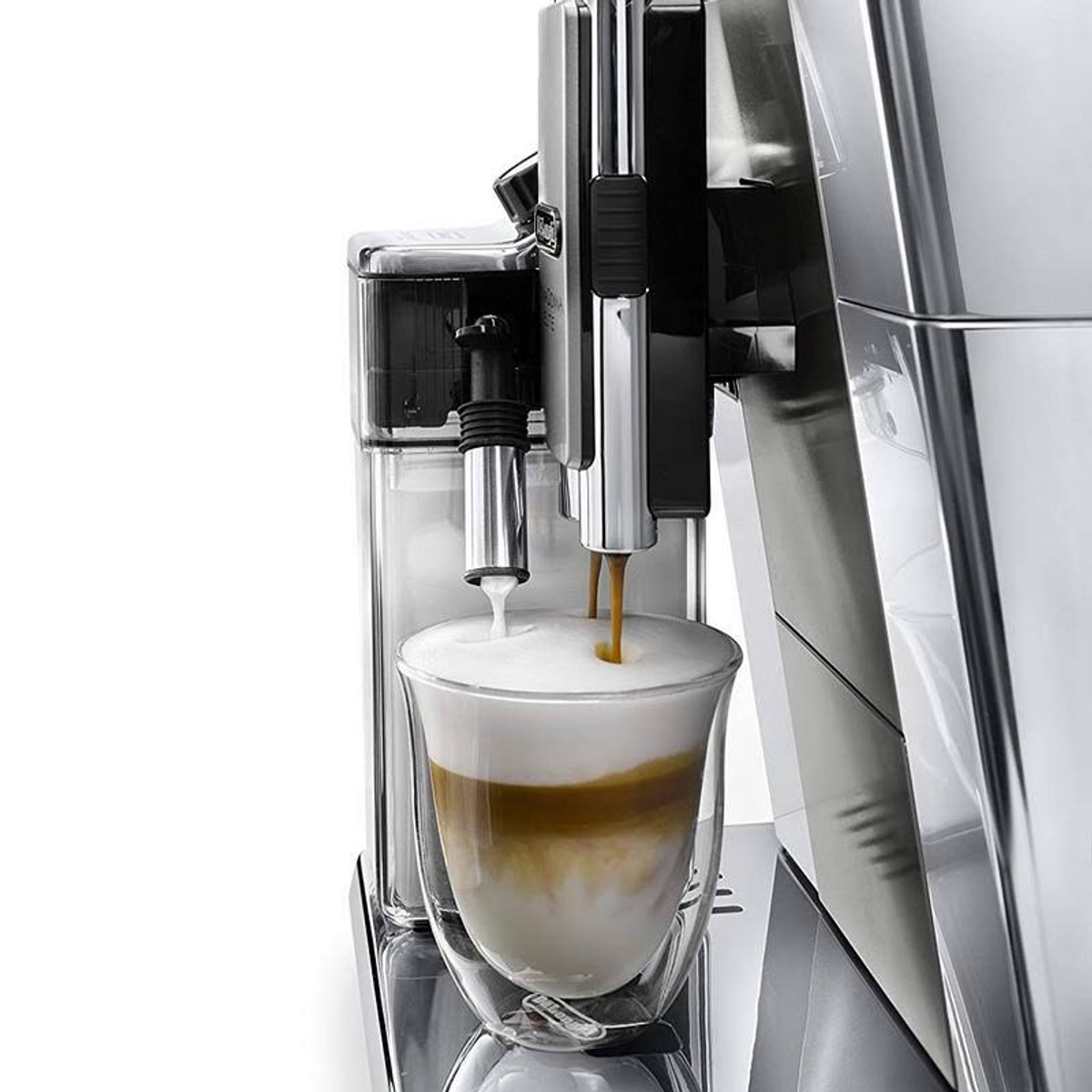 Espressomaschine gießt Kaffee in ein Glas, geschichtet mit Milch, Kaffee wird gezeigt.