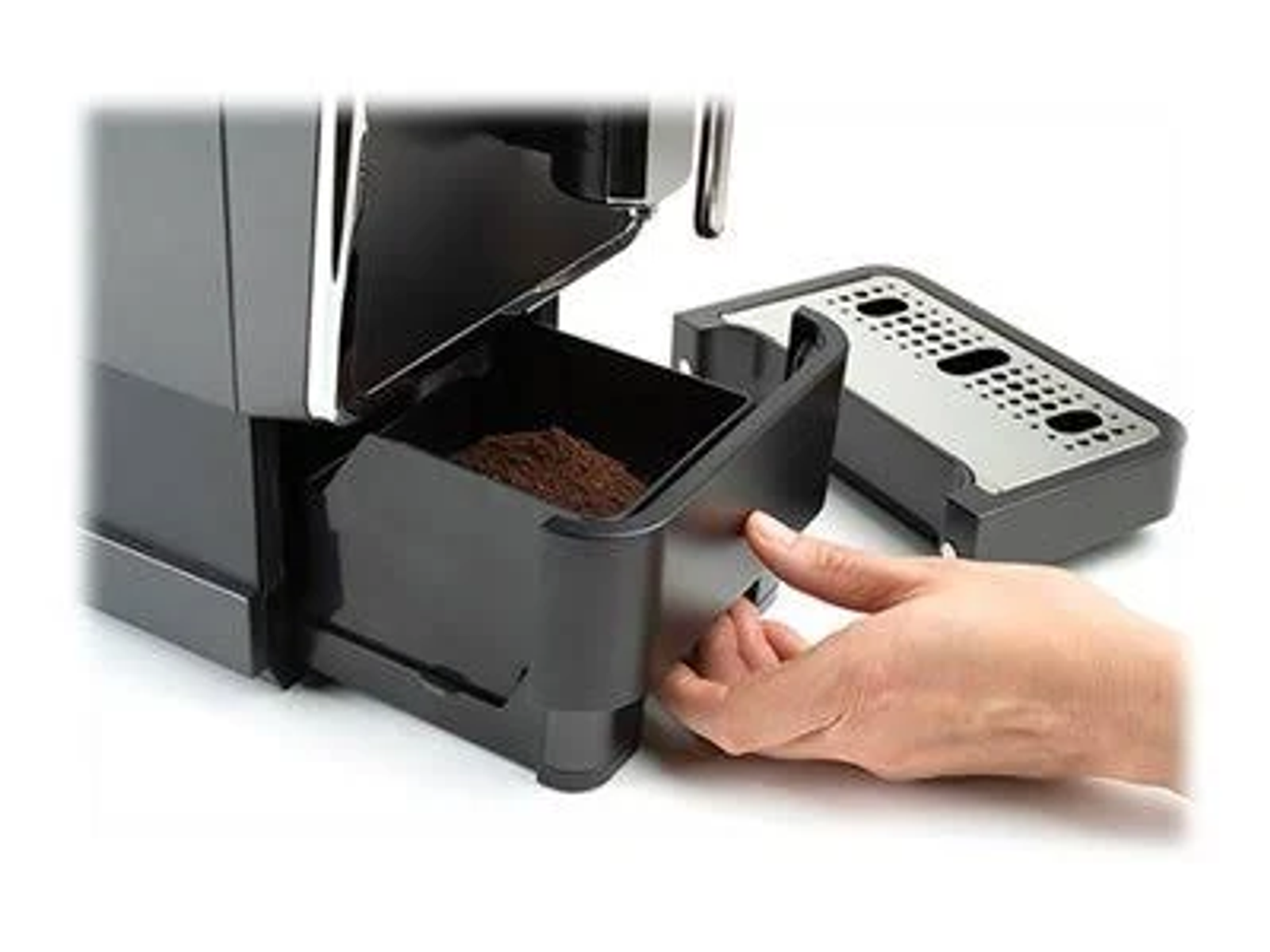 Czarny ekspres do kawy z wysuniętą szufladą, wypełnioną fusami, na białej powierzchni.