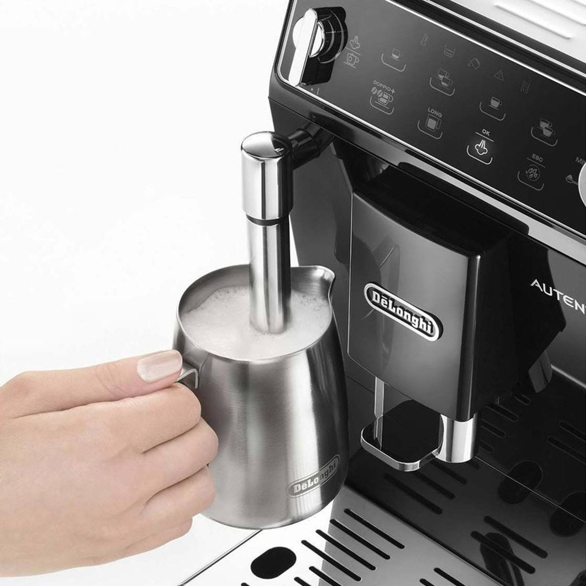 Een persoon gebruikt een melkopschuimer op een zwart-zilveren koffiemachine.