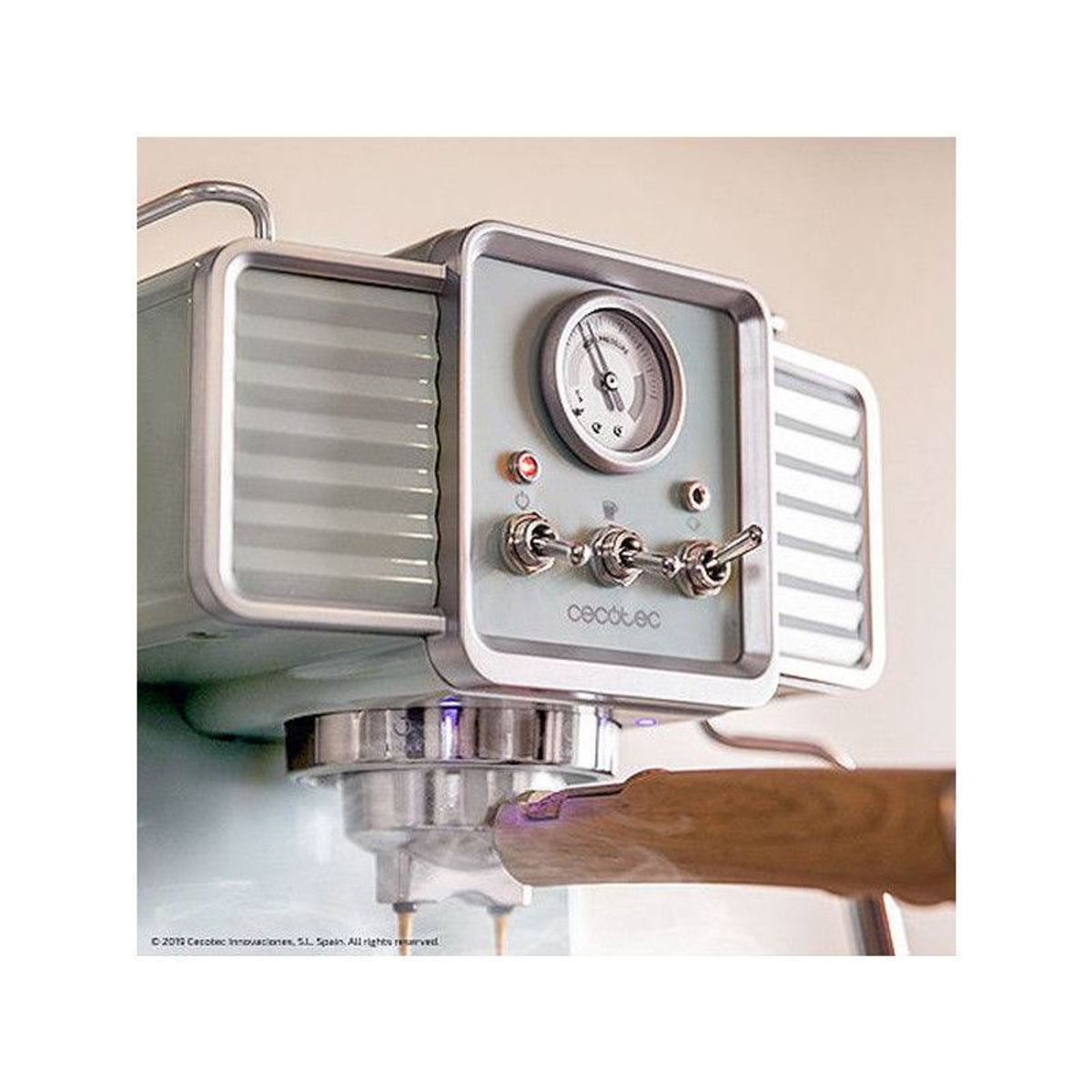 Ekspres do kawy z szarym i srebrnym przodem. Posiada wskaźnik i chromowane detale.