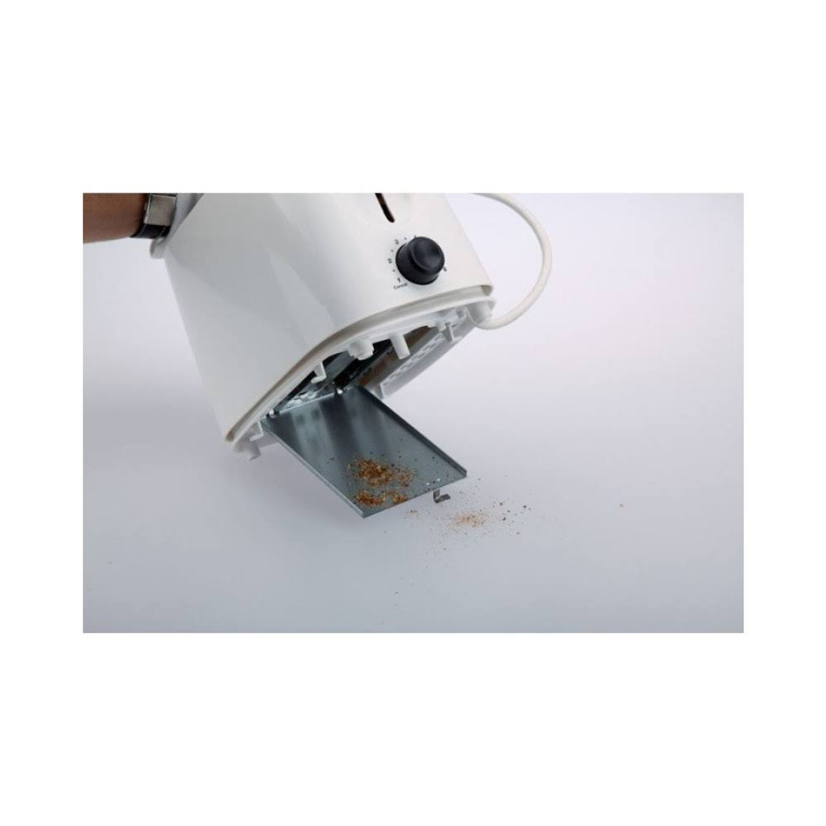 Biały toster przechylony, taca na okruchy otwarta, widoczne okruchy. Białe tło.