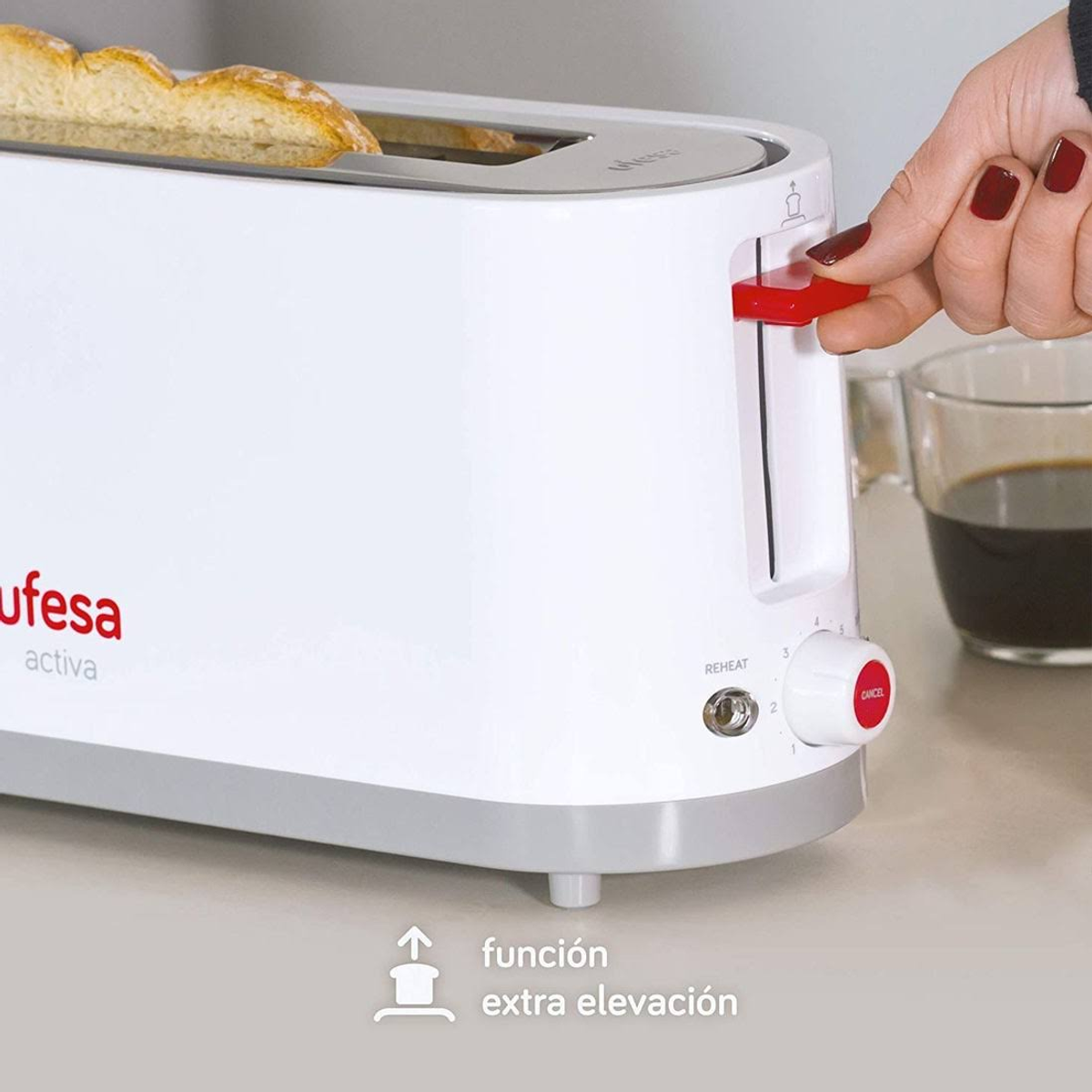 Biały toster z czerwonym dźwignią w dół. Kawa i chleb na blacie.