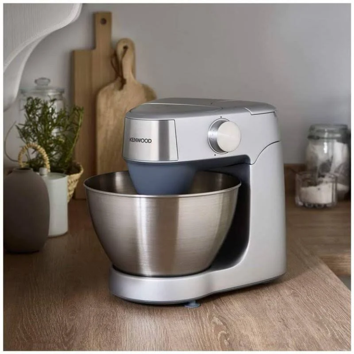 Frullatore da cucina argentato con ciotola in acciaio inox, su superficie in legno.
