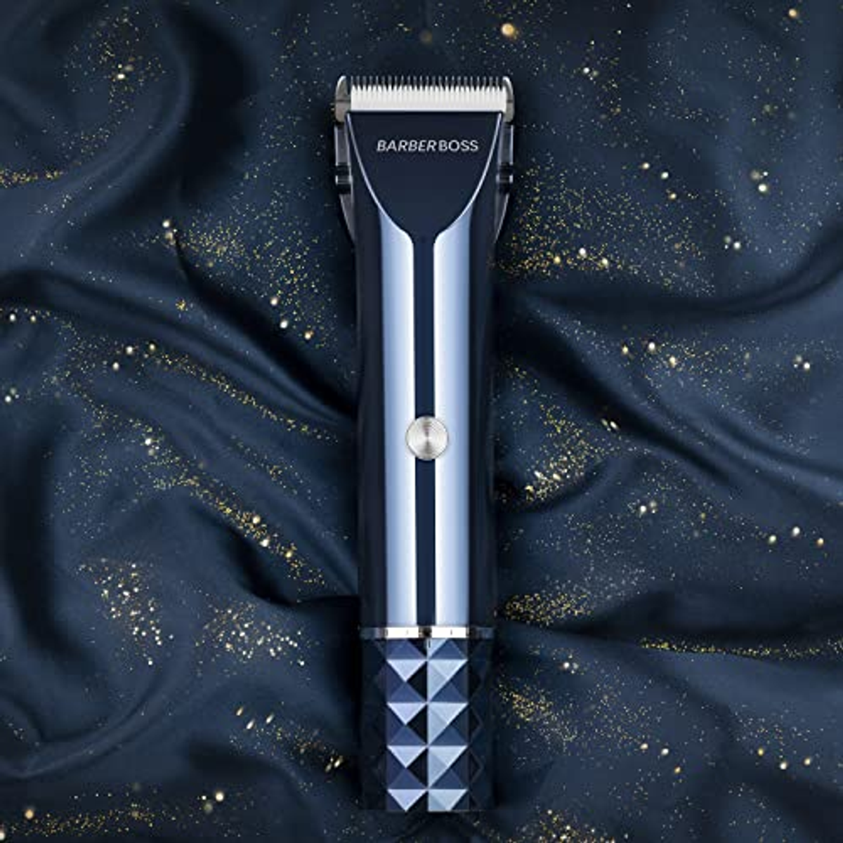 Un tagliacapelli blu e argento su un tessuto blu scuro con macchie dorate.