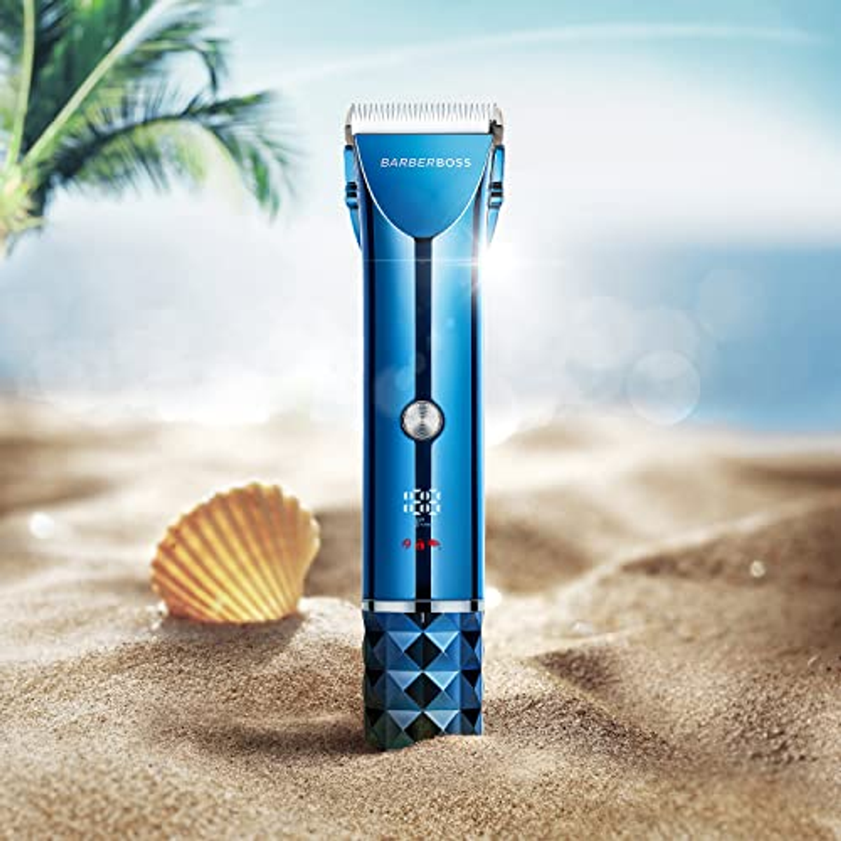 Ein blauer Barberboss Haarschneider auf Sand mit einer Muschel. Der Hintergrund zeigt blaues Meer und Himmel.