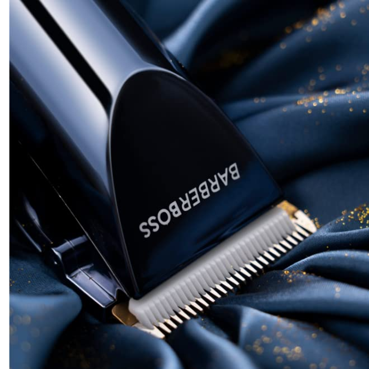 Nahaufnahme eines schwarzen Haarschneiders auf glänzendem, dunkelblauem Stoff mit Goldglitter.