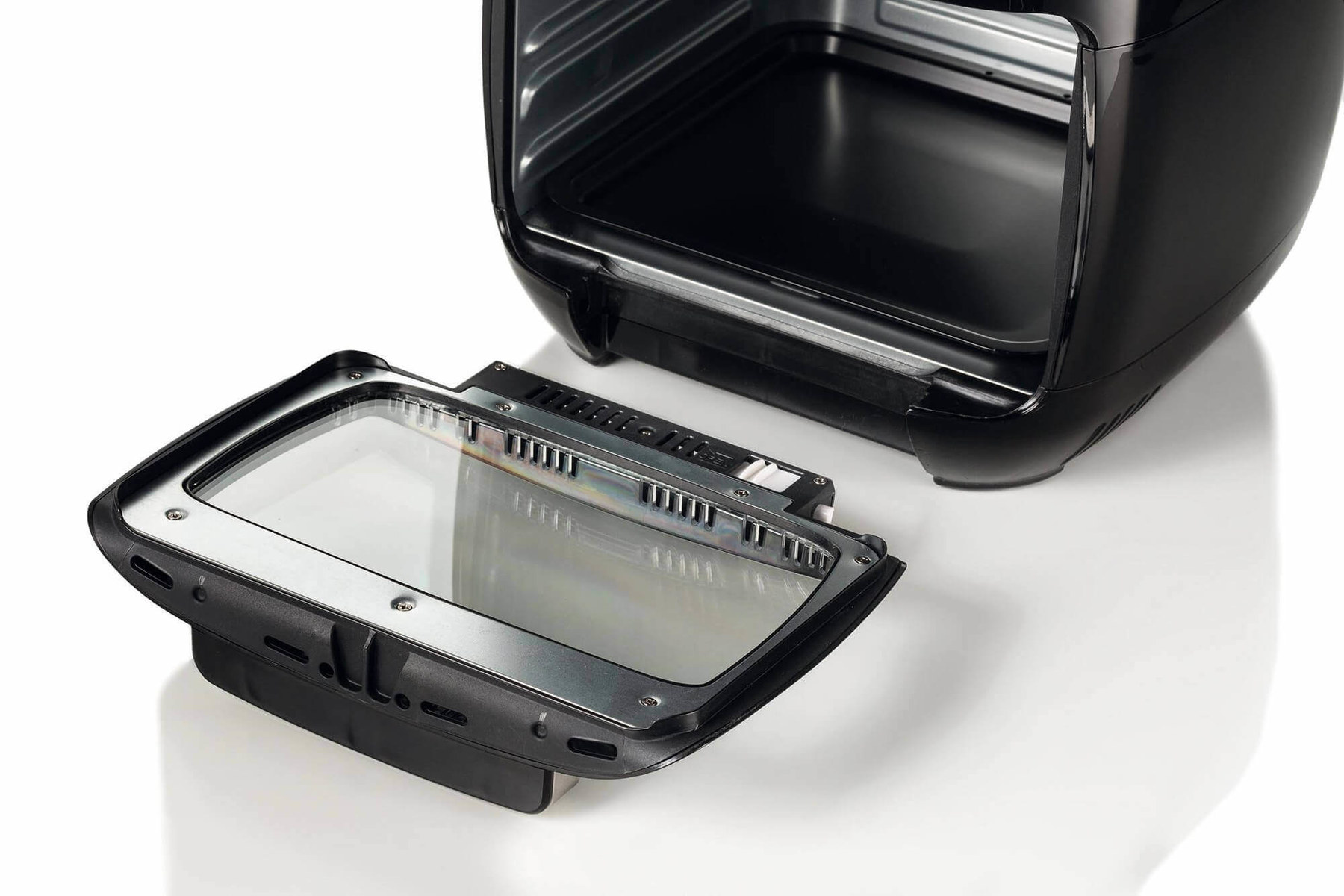 Czarna frytkownica powietrzna z otwartą pokrywą, widok wnętrza. Białe tło.