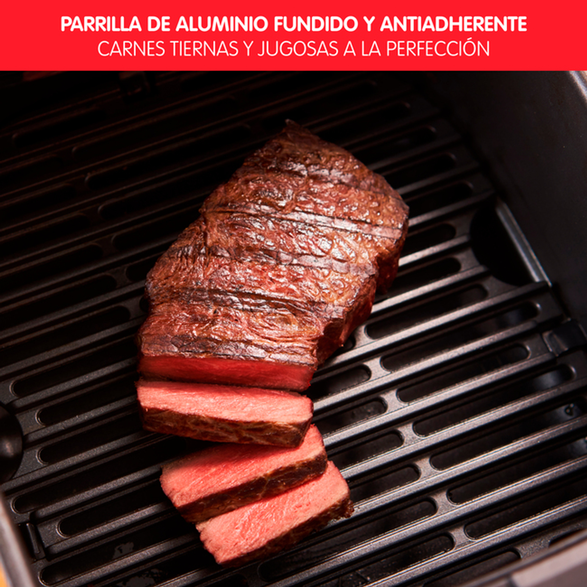 Zbliżenie grillowanego steku na czarnym grillu. Pokrojony stek pokazuje czerwone mięso i ślady po grillu.