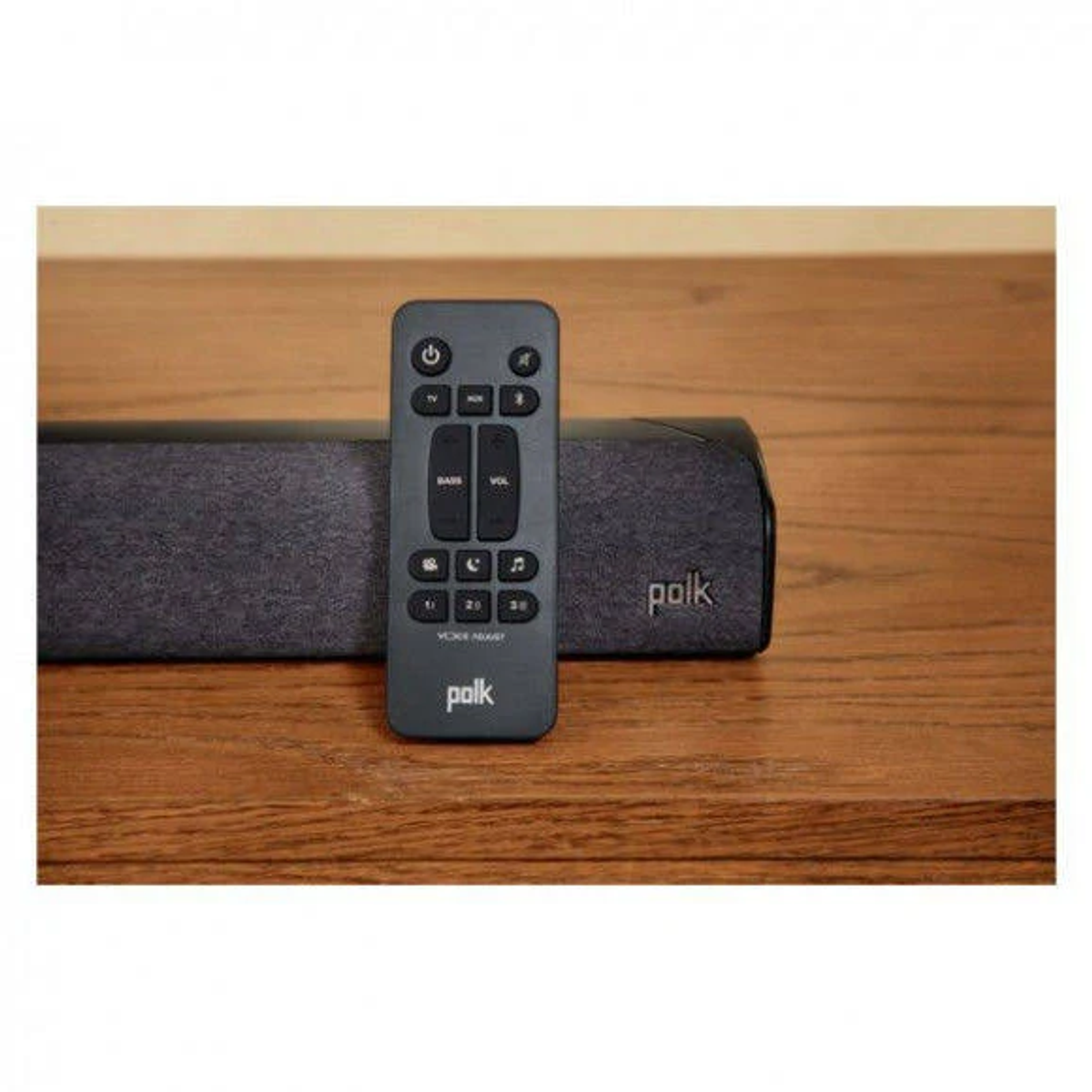 Polk Soundbar und Fernbedienung auf einer Holzoberfläche.