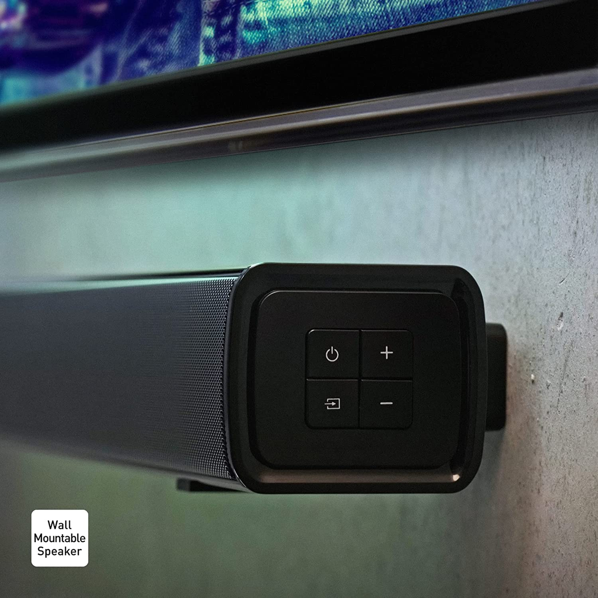 Czarny głośnik soundbar zamontowany na ścianie z przyciskami. Przyciski to zasilanie, zwiększanie głośności, zmniejszanie głośności i źródło.