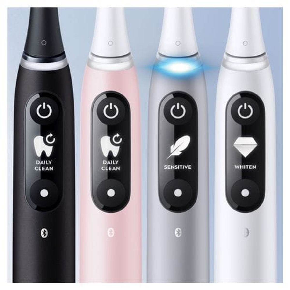 Primer plano de cuatro cepillos de dientes eléctricos. Negro, rosa, gris y blanco con modos diferentes.