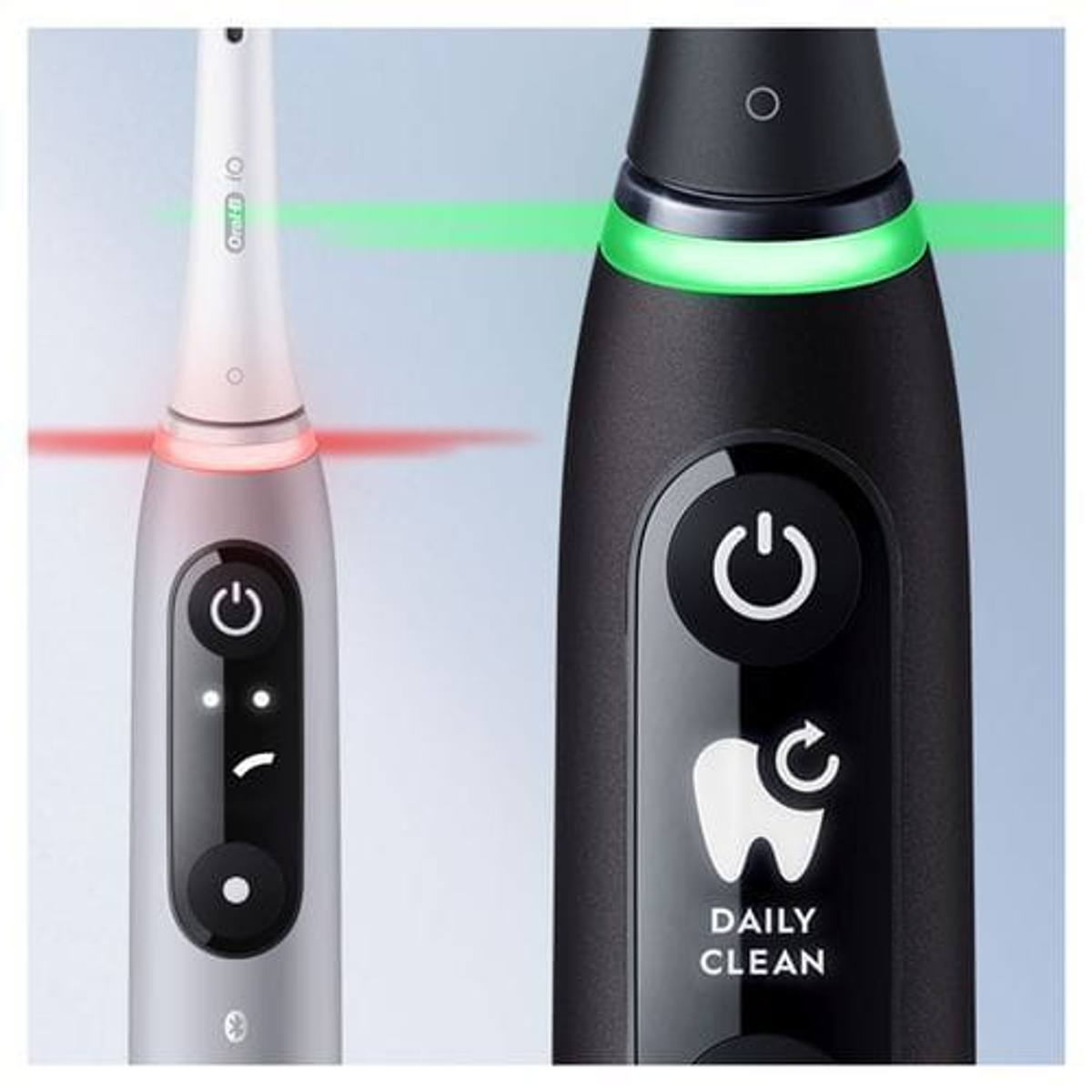 Dos cepillos de dientes eléctricos, uno plateado y otro negro, con botones de encendido.
