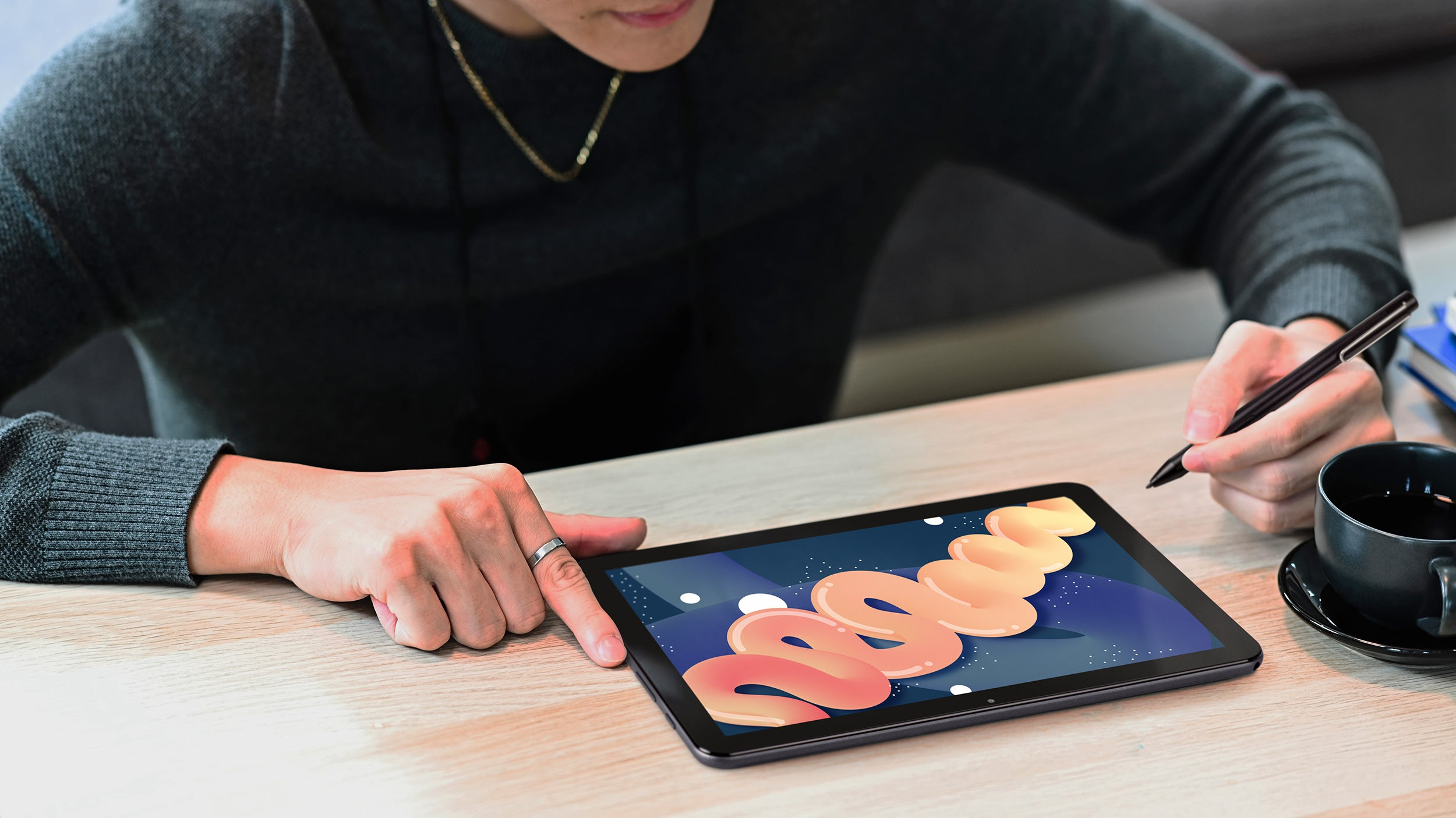 Una persona disegna su un tablet con una penna. Il tablet mostra testo colorato.
