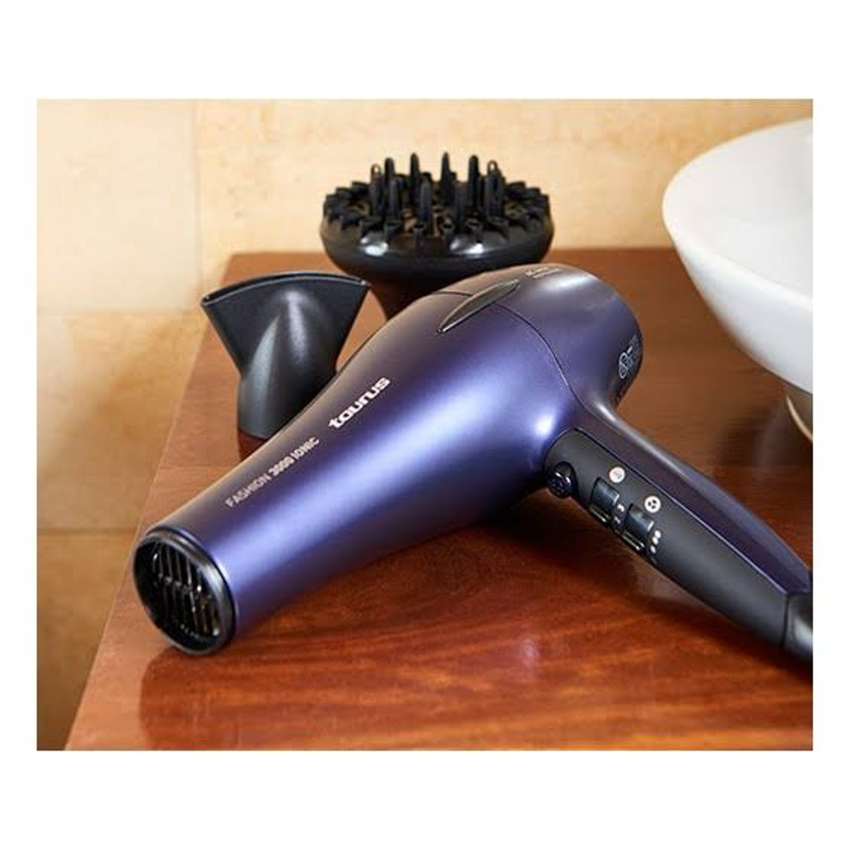Fioletowa suszarka do włosów z nasadkami na drewnianej powierzchni.