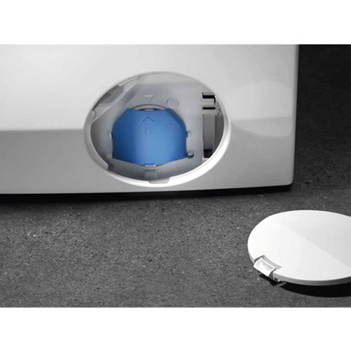 Szczegół pralki z niebieskim elementem widocznym przez okrągły otwór i odłączoną białą pokrywą.